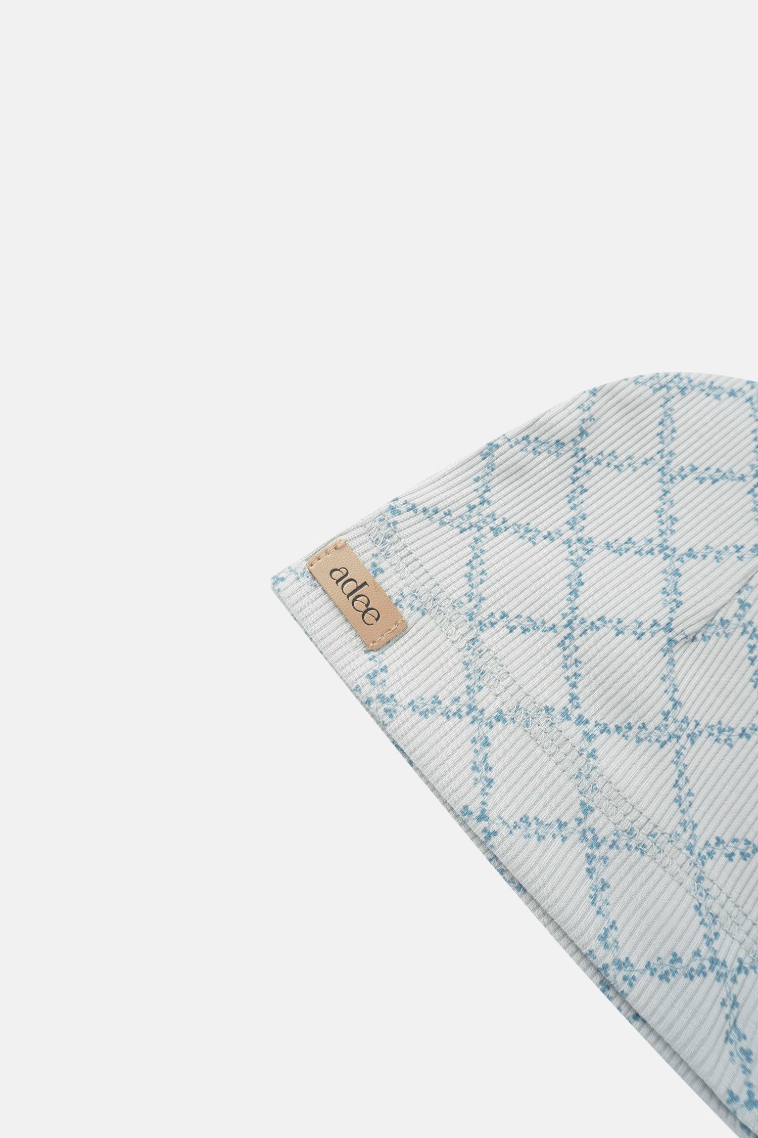 Blue leaf hat for boys by Adee; light gray plaid fabric with blue leaf pattern and brand tag.