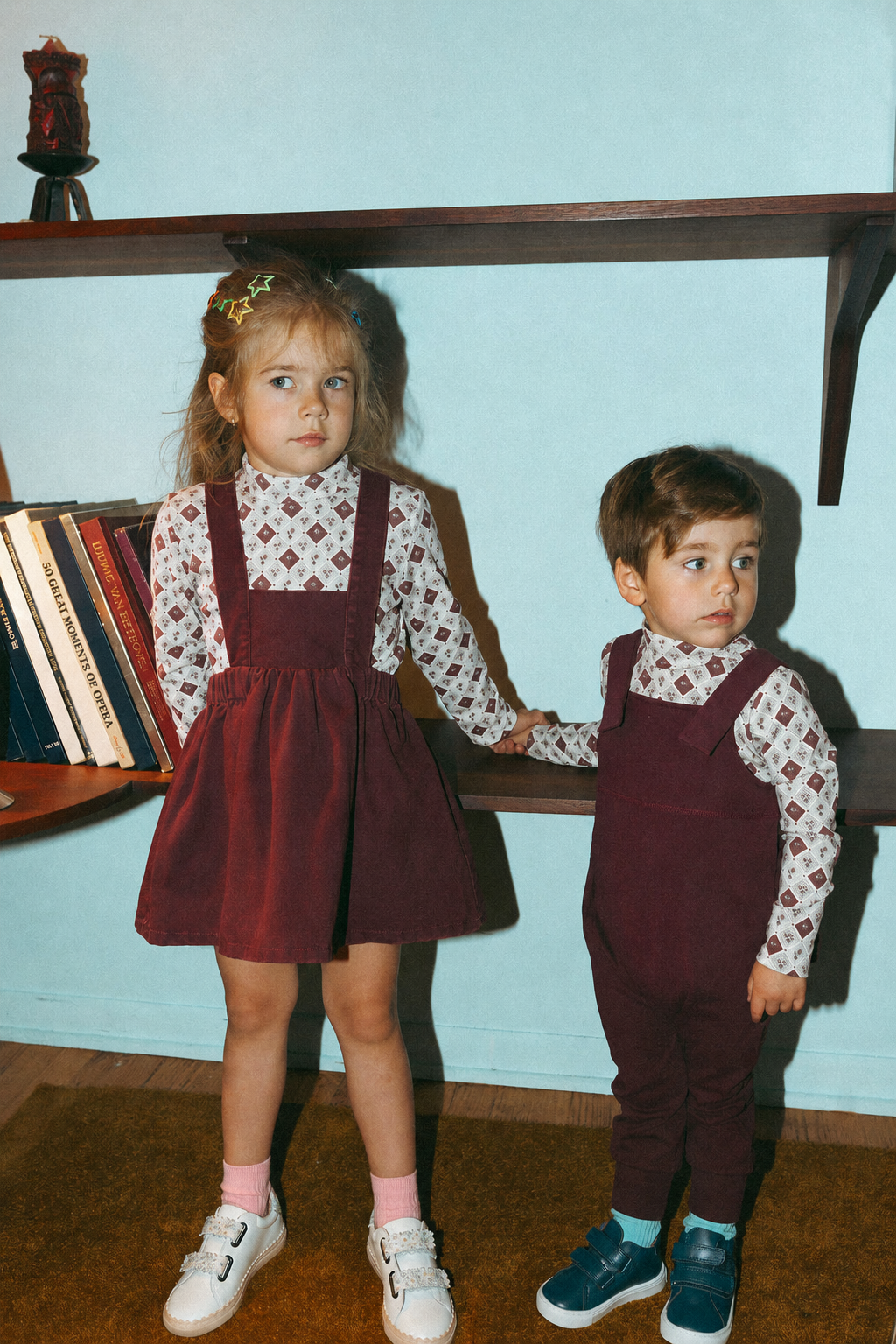 Mosaic Floral Mock Neck T-Shirt for girls; two kids wear burgundy pinafores with patterned white tops.