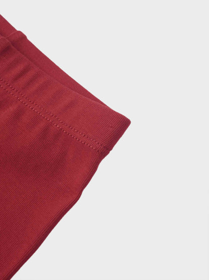 Non ribbed leggings in red, close-up of the cuff with stitched hem.