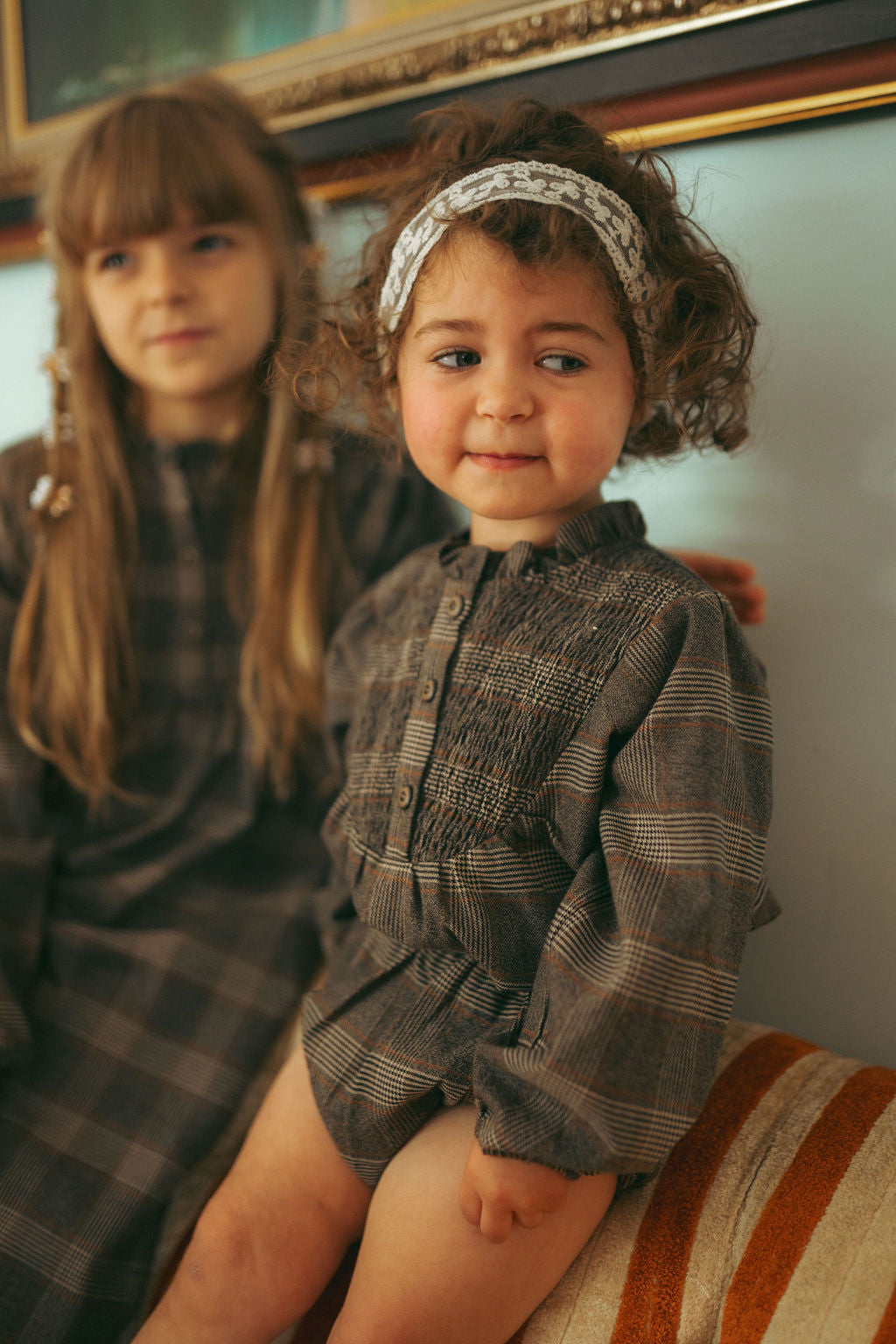 Plaid shirt and bloomers set for little girls in grey; two children wearing matching dressy grey plaid outfits.