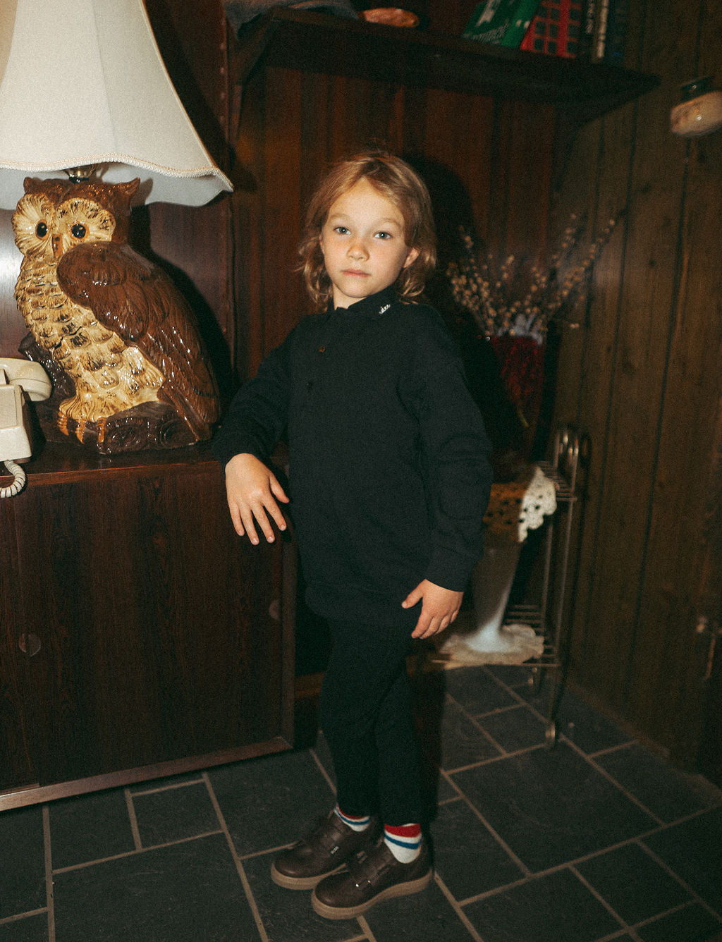 Collared black Adee sweatshirt for unisex tops, worn by a child model