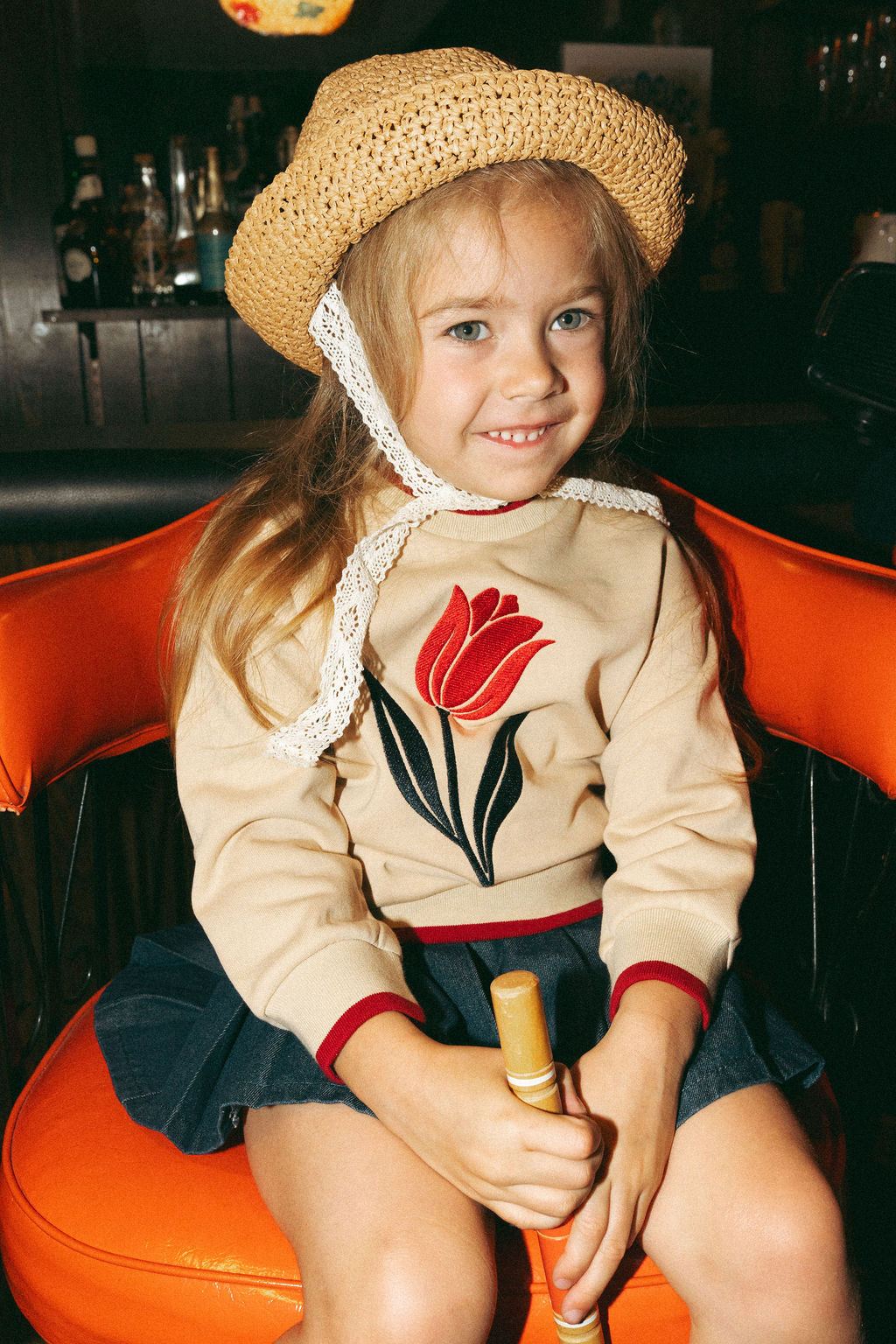 Embroidered Tulip Sweatshirt by Adee, beige with red tulip embroidery, worn by a girl.