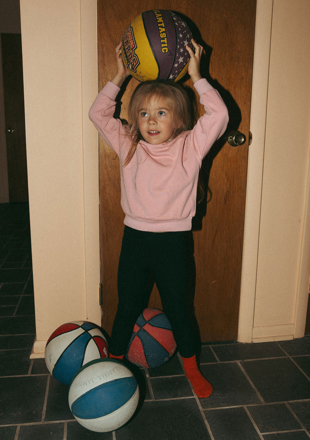 Adee pink contrast mock neck sweatshirt for girls; girl holds a basketball above her head with three balls on the floor.