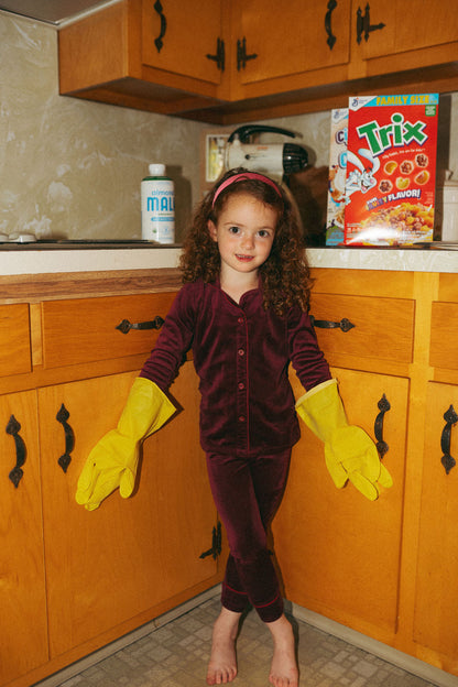 Girls burgundy ribbed velour pajamas worn by a young girl in a kitchen