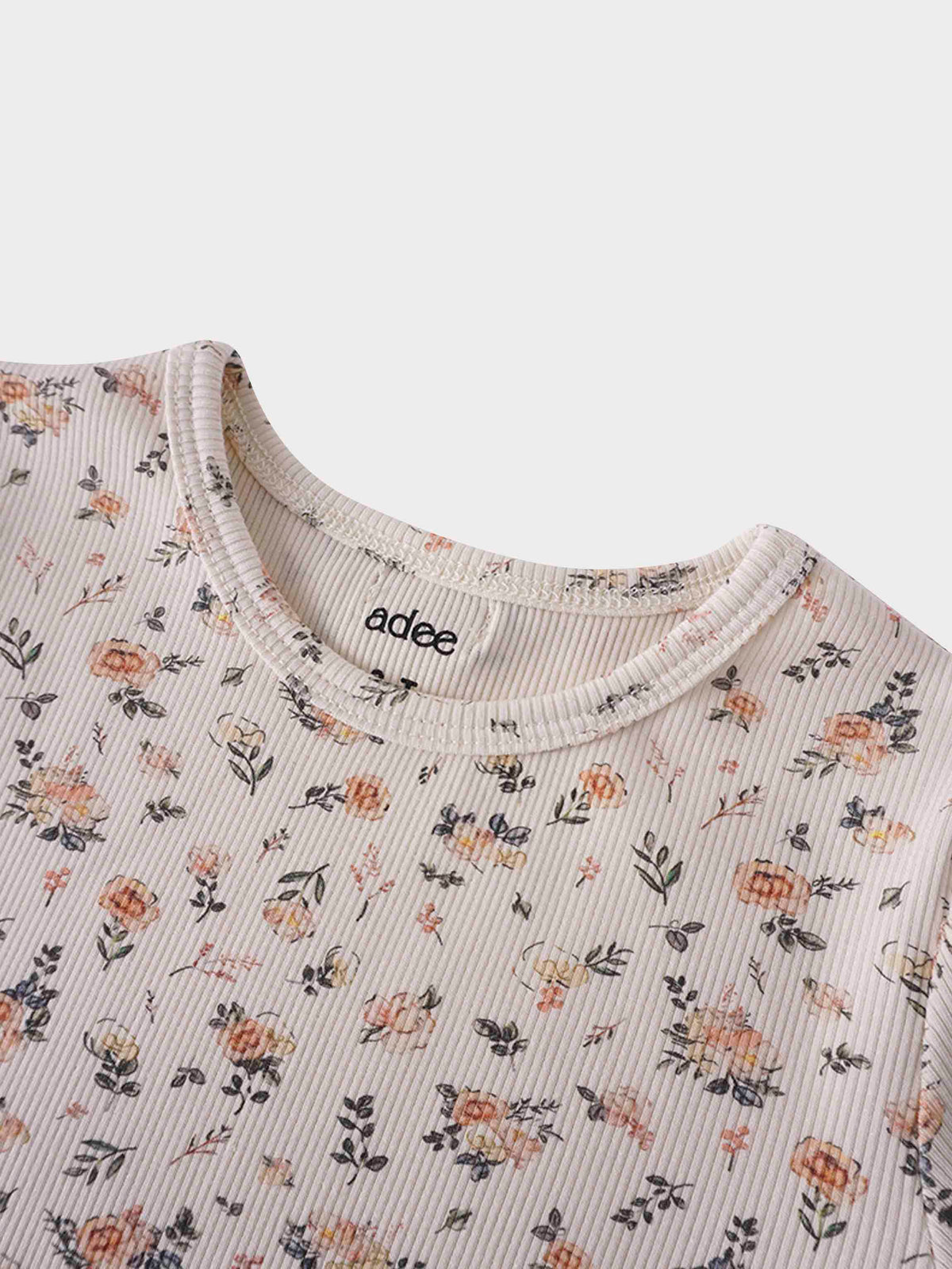 Petit Floral Dress: off-white ribbed fabric with hand-painted pink flowers and green leaves.
