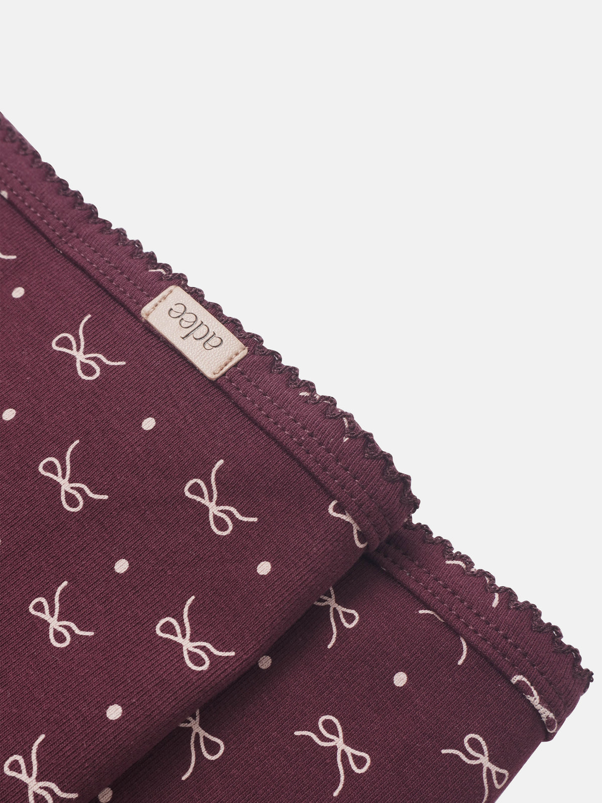 Burgundy bow blanket for girls swaddle with white bows and polka dots, Adee brand, scalloped edge