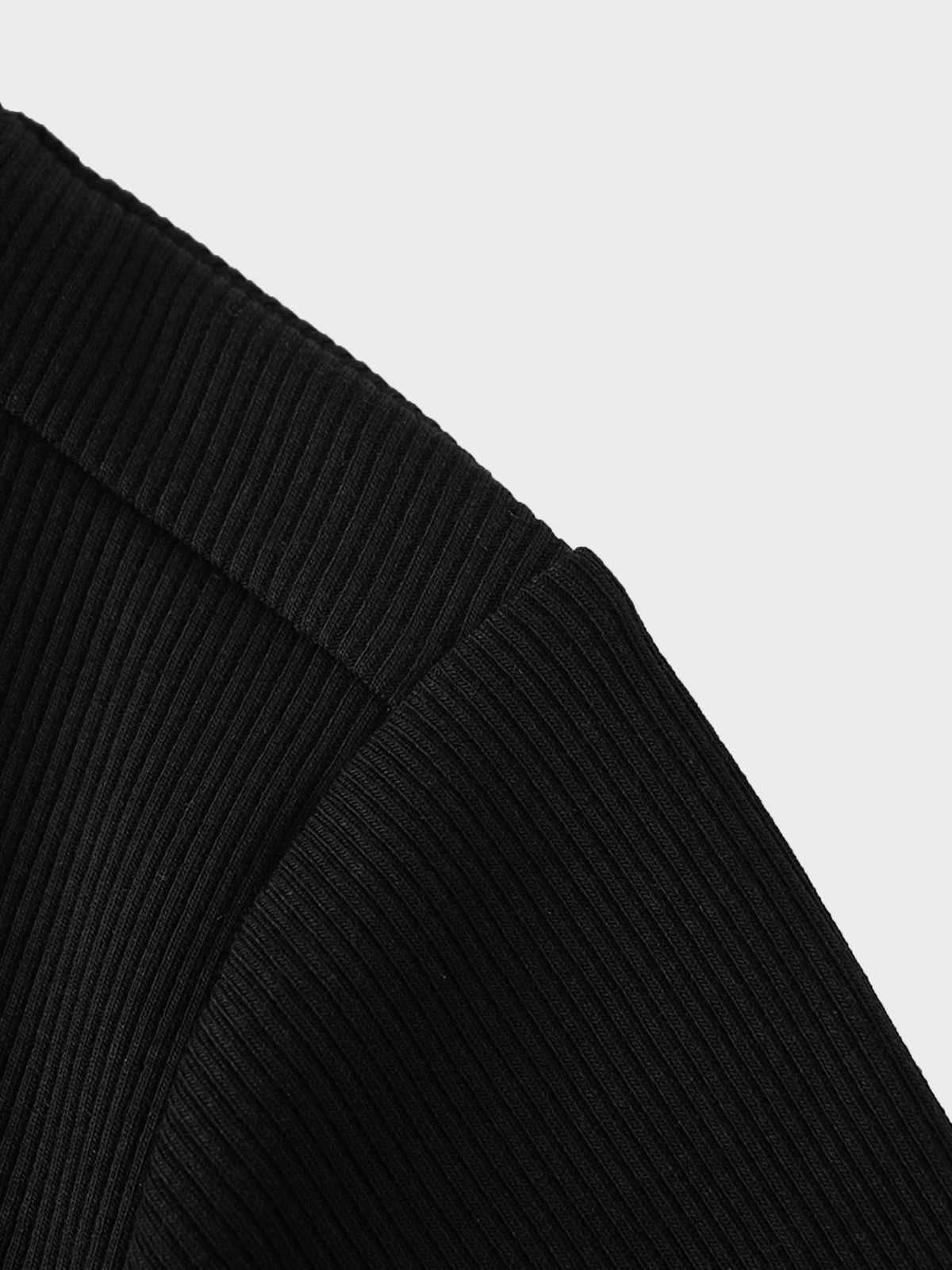 Close-up of black, thin ribbed zip sweatshirt fabric at the shoulder seam.