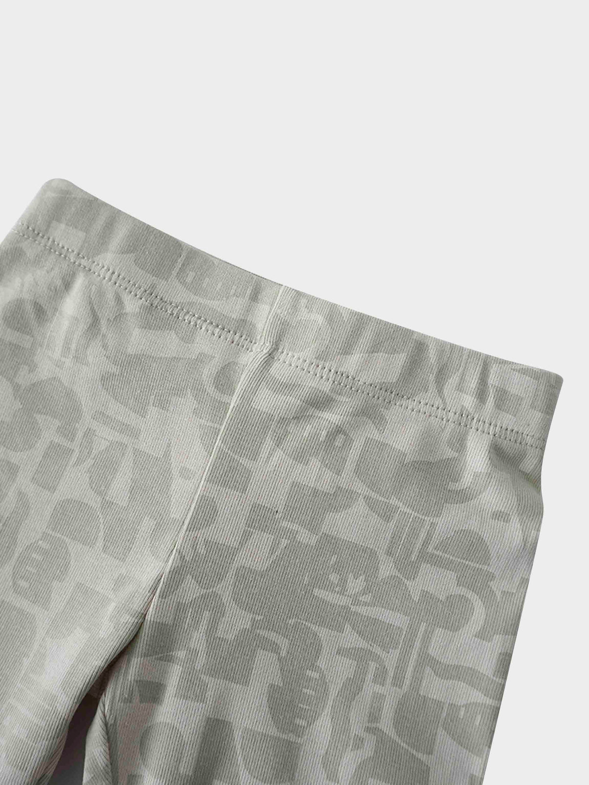 Close-up of light gray camouflage-patterned pajama fabric with a stitched waistband seam