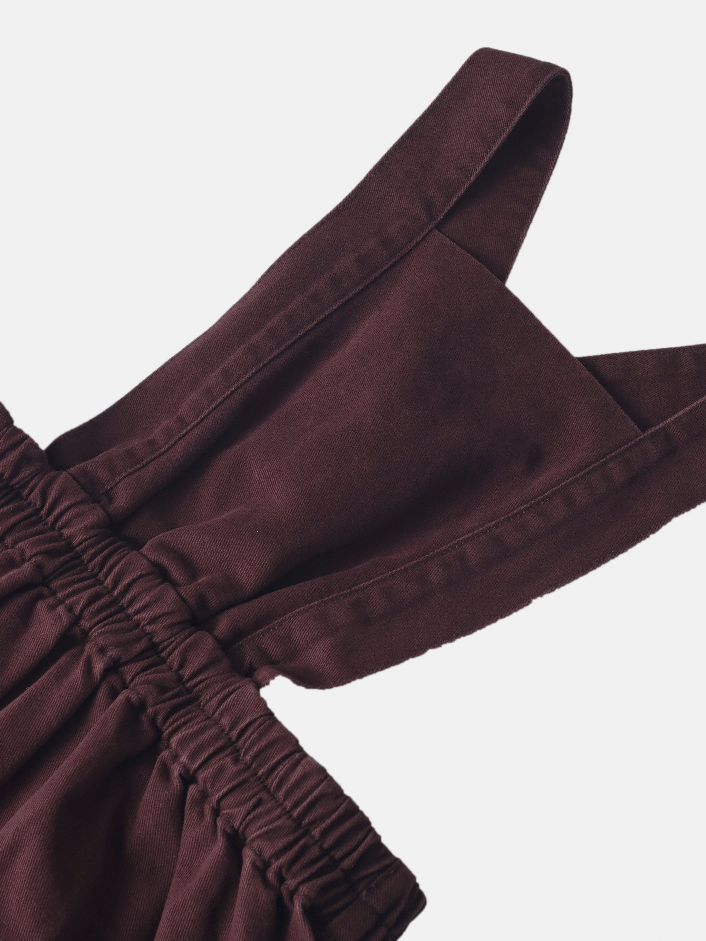 Denim jumper in burgundy with shoulder strap and elasticated cuff