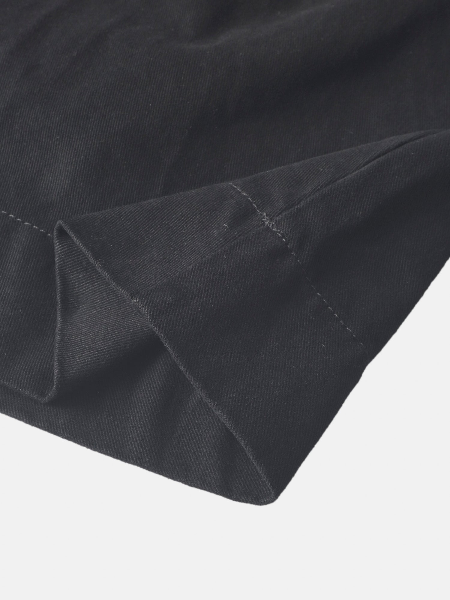 Denim jumper dress for girls in black by Adee; close-up of dark denim fabric and stitching.