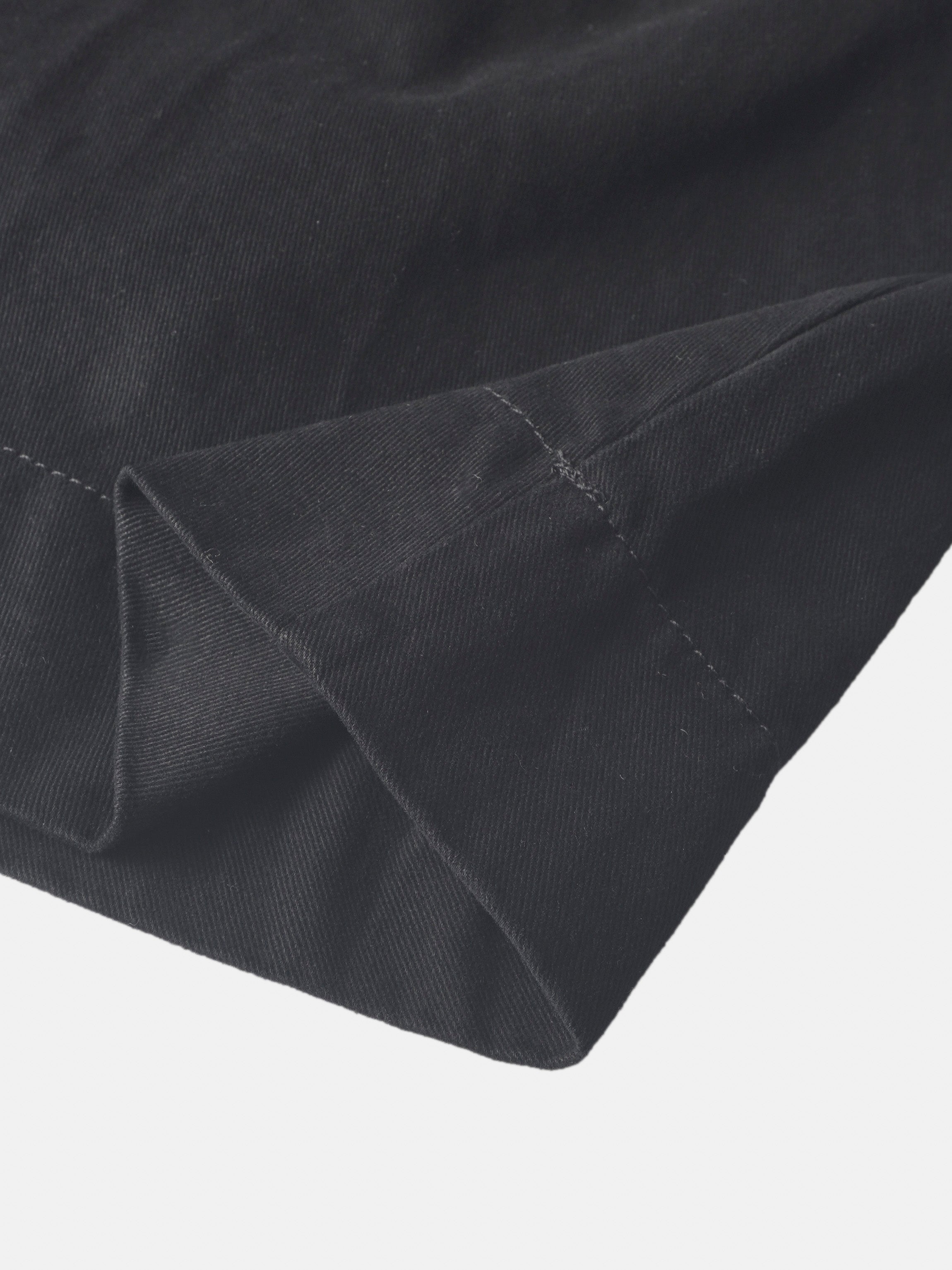 Denim jumper dress for girls in black by Adee; close-up of dark denim fabric and stitching.