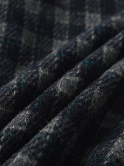 Plaid navy pants fabric close-up with green accents and wool-like texture