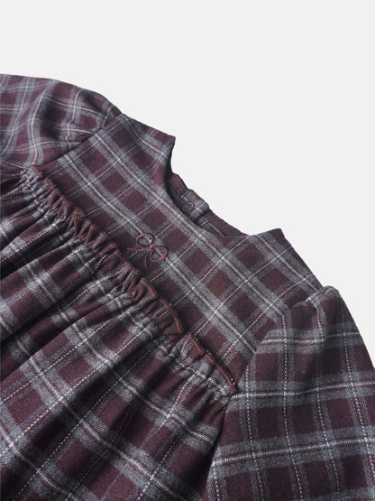 Girls burgundy plaid romper close-up showing elastic waist and buttoned neckline