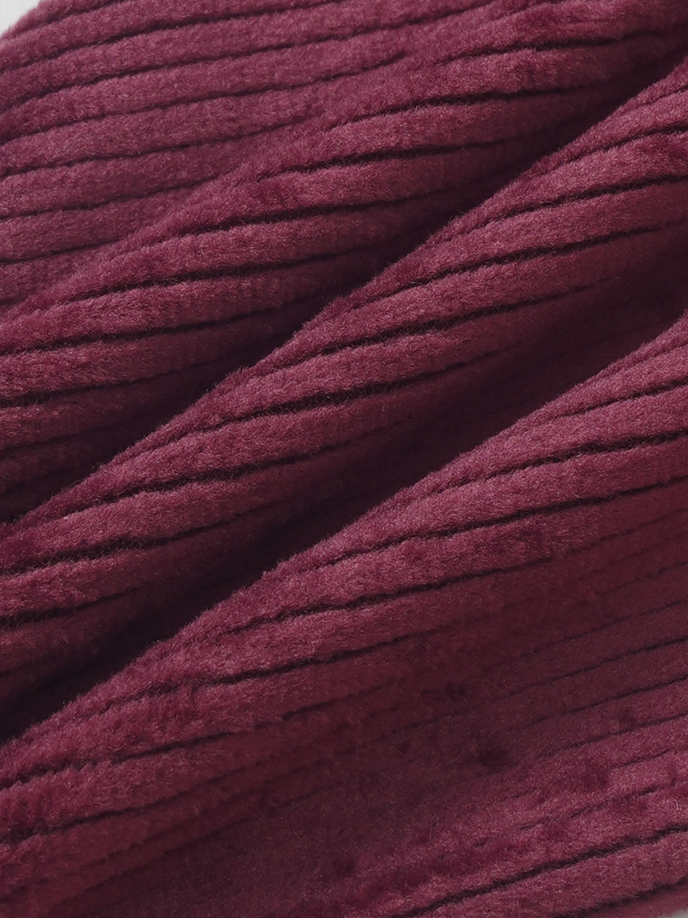 Girls burgundy ribbed velour pajamas fabric close-up, plush textured material for comfortable fit and cozy nights