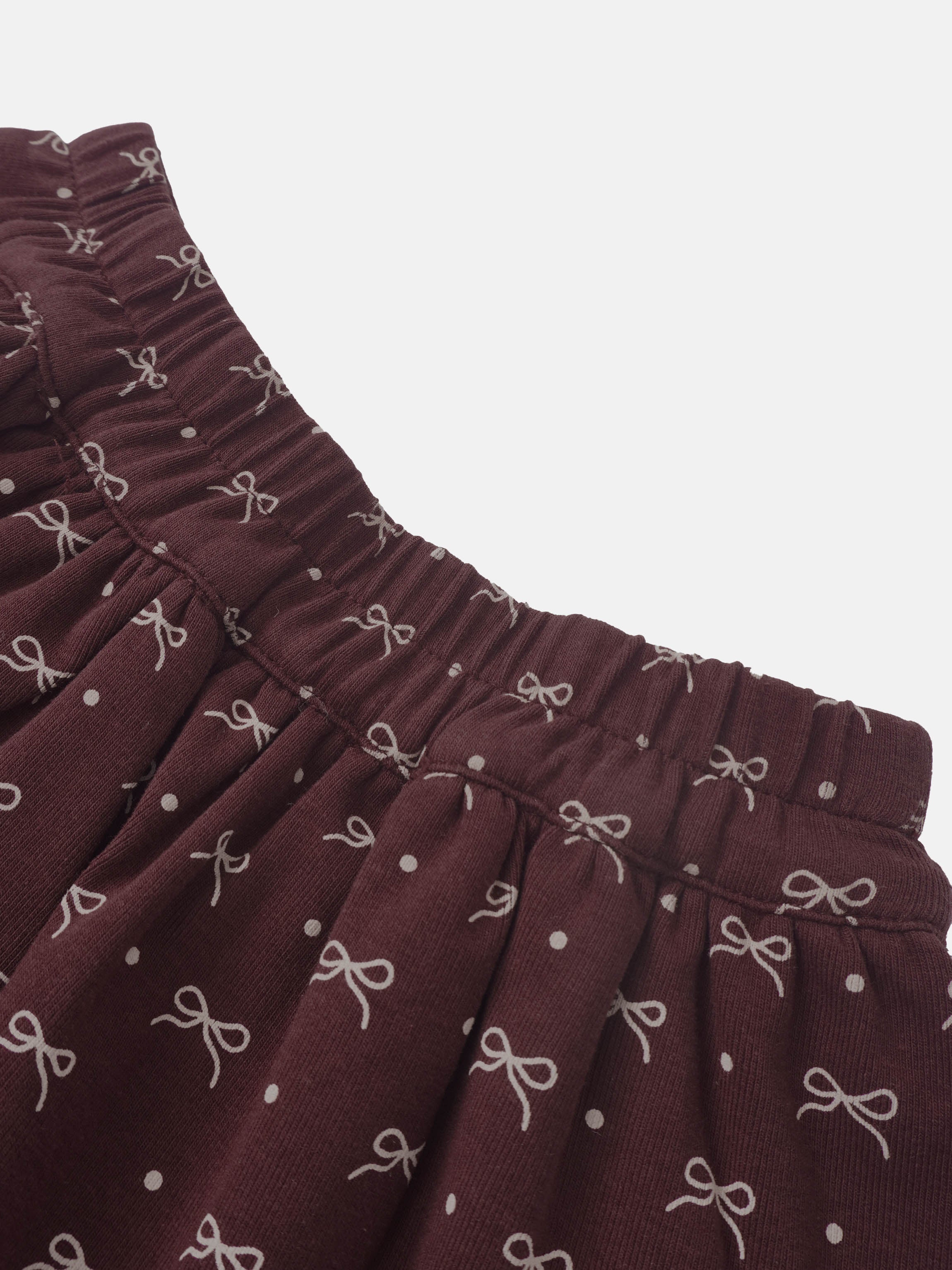 Adee burgundy bow-layered girls skirt with elastic waistband and white bow pattern.