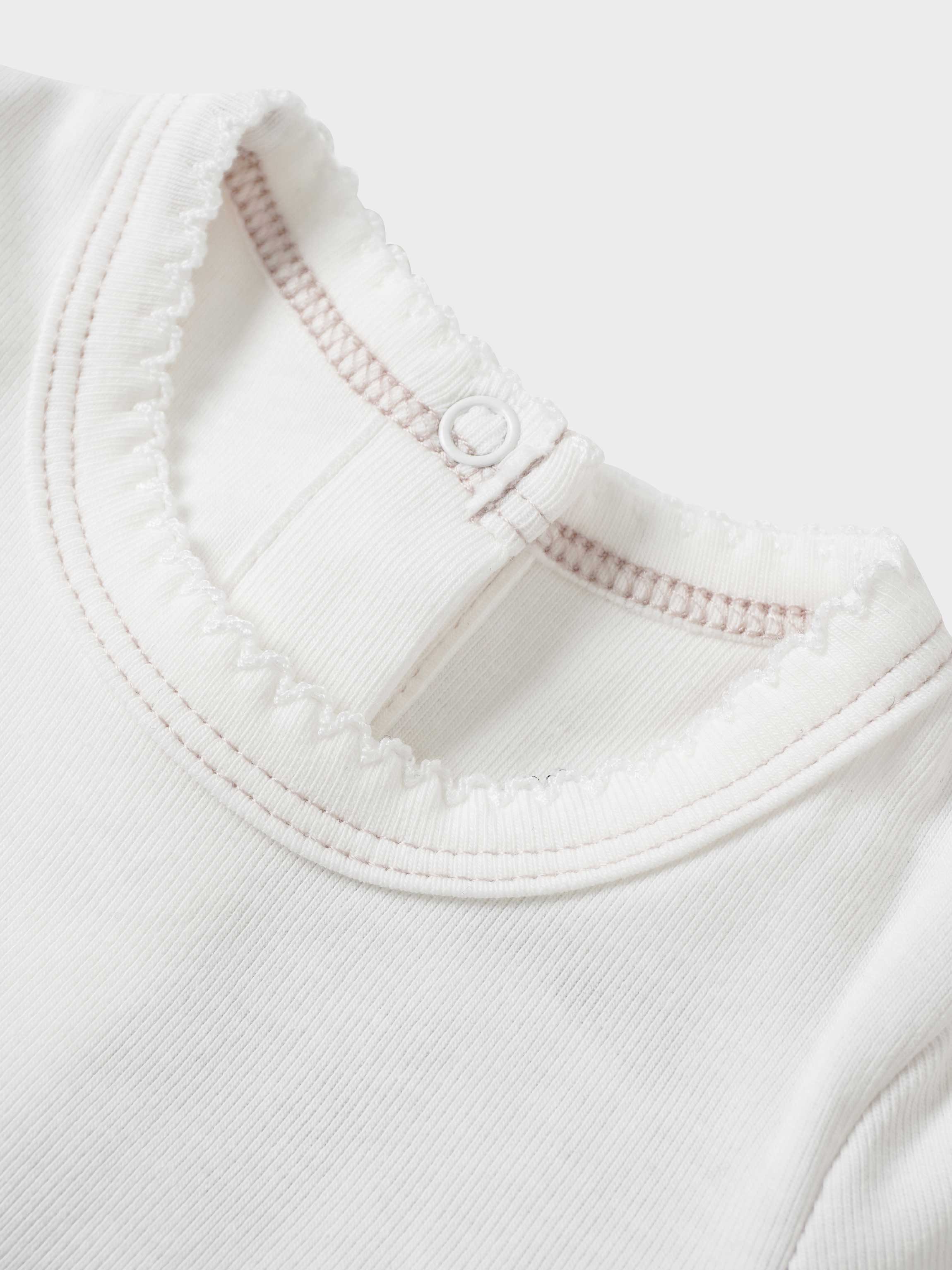 Mini Gallery Stretchy pink girls top close-up of white knit neckline with pink trim Adee