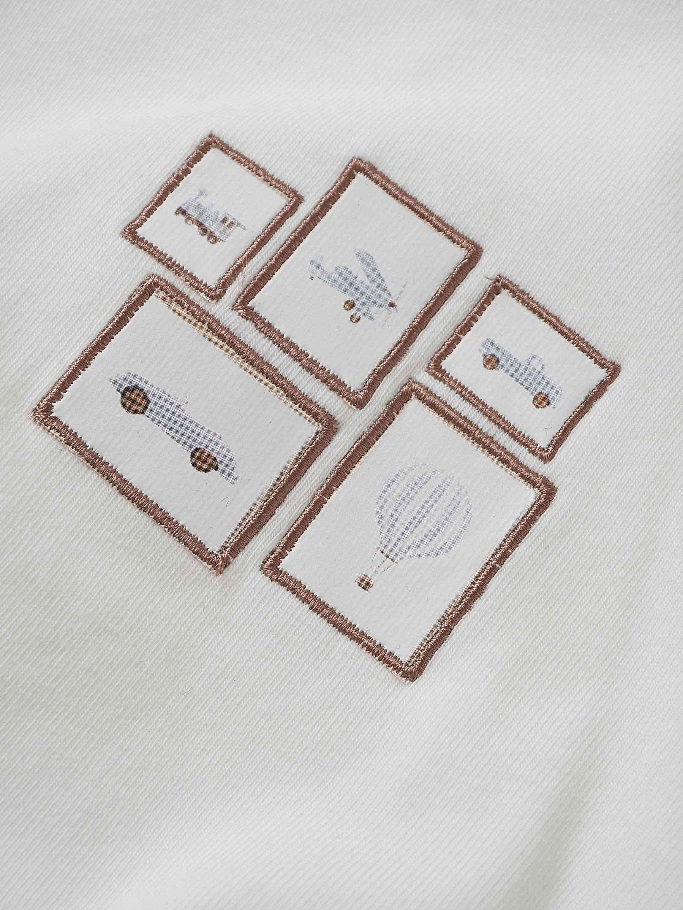 Mini Gallery Romper Blue and white baby romper with light blue embroidered vehicle patches