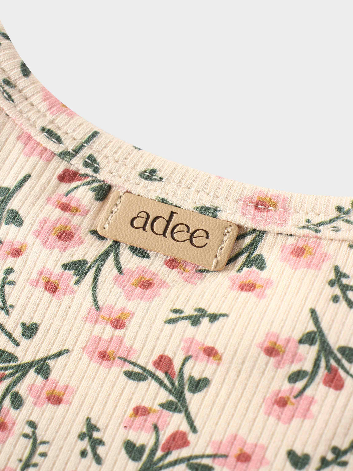 Beige fabric with pink and green floral print and a tan adee brand patch.