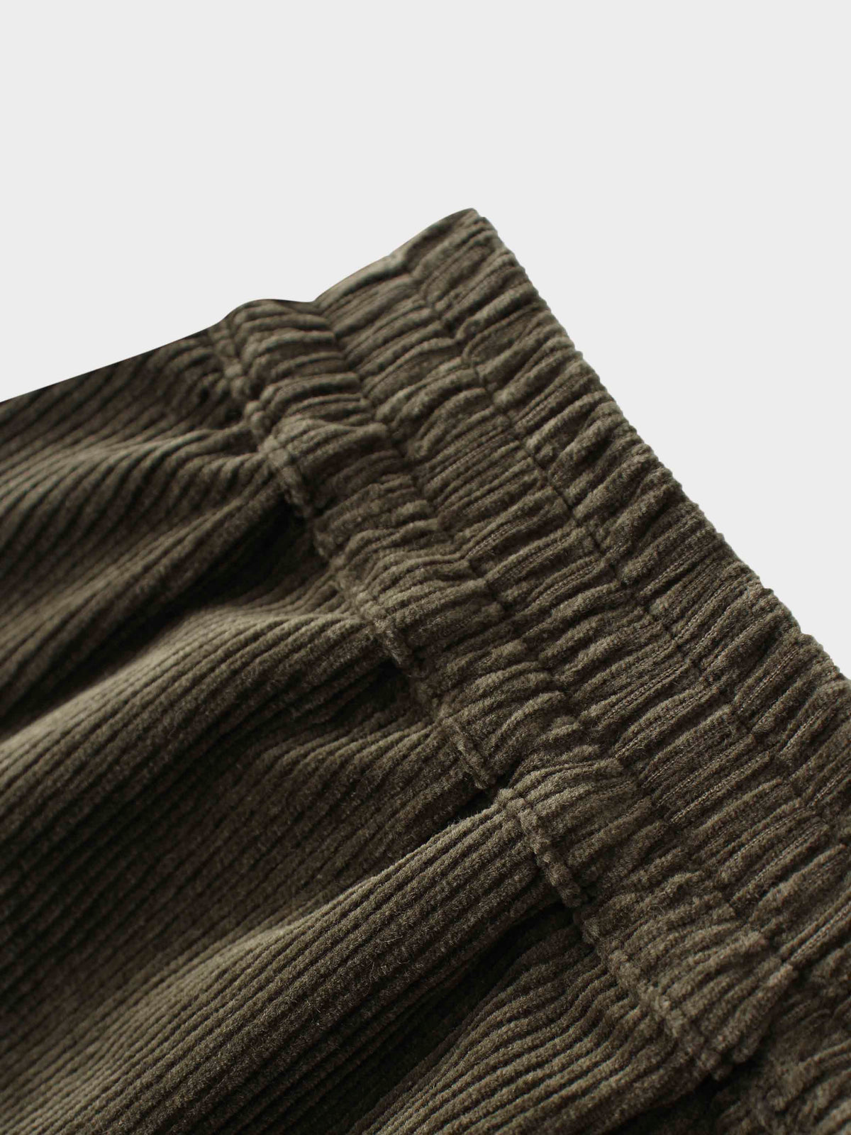 Close-up of forest green corduroy fabric with vertical ribbing.