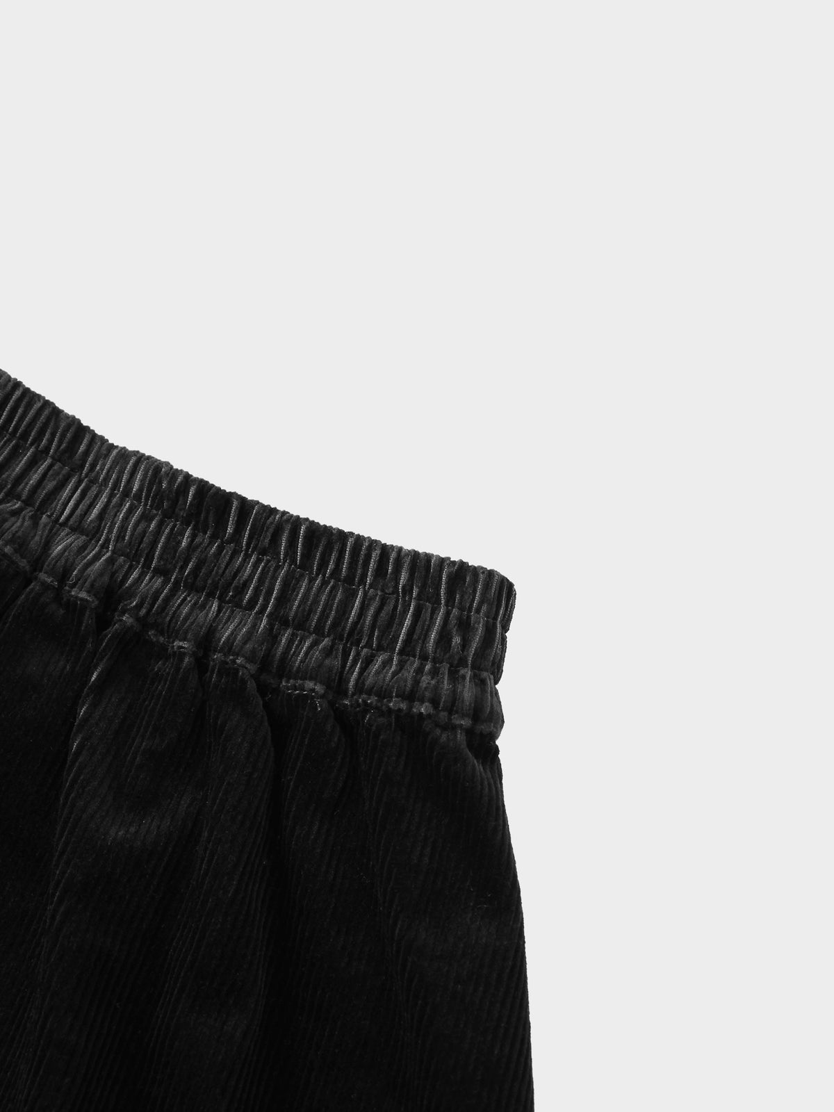 Corduroy skirt for girls in black with elastic waistband, textured fabric.