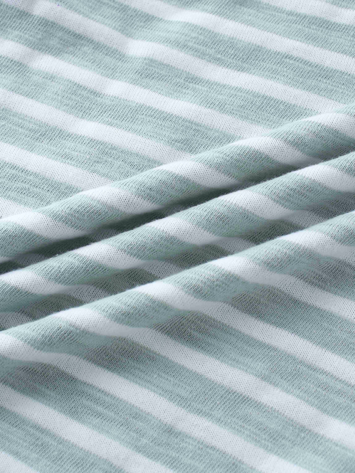 Pastel green and white striped knit fabric close-up for a boys&