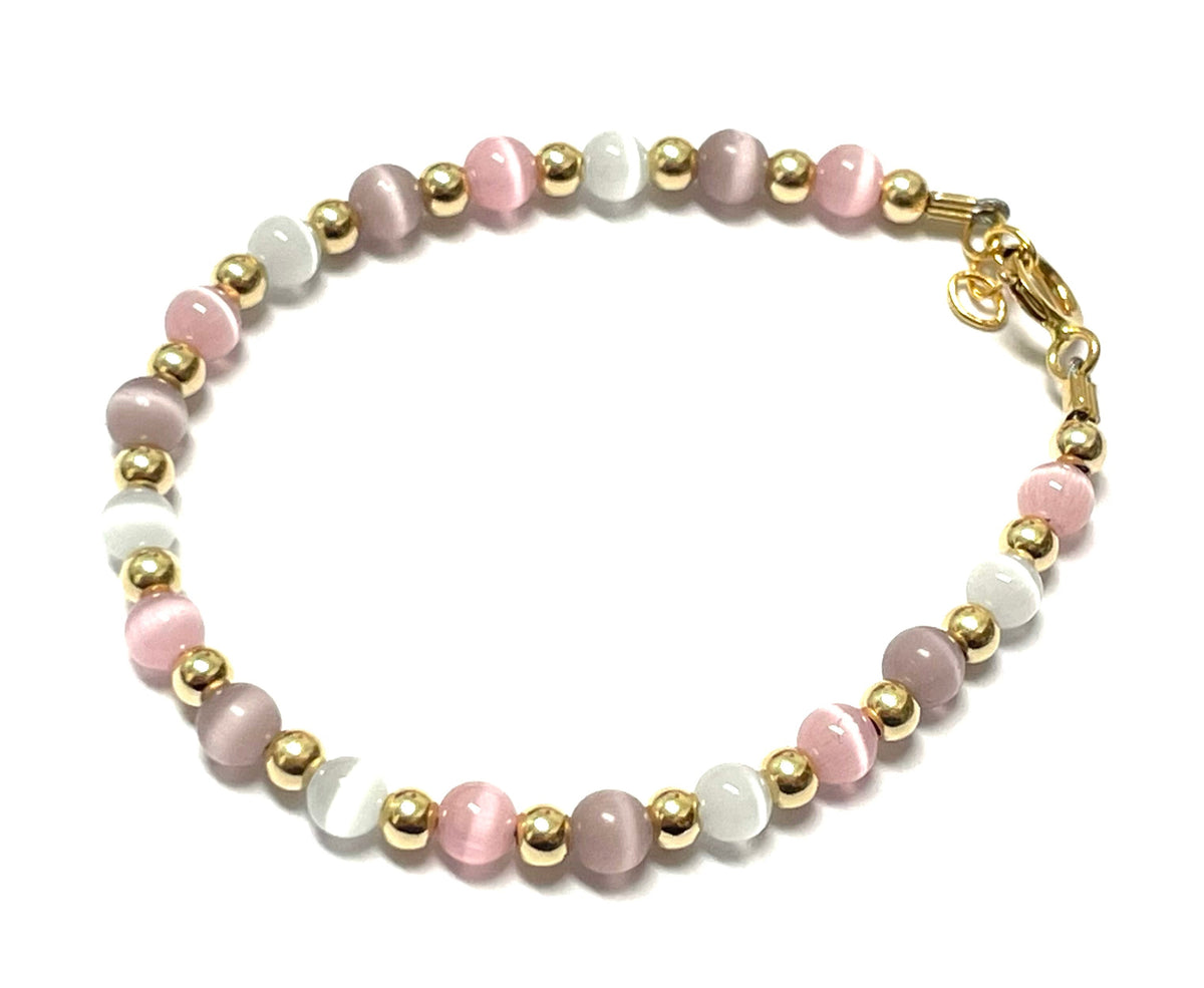 Beaded bracelet in pastel pink, white, and lavender with gold spacers and a gold clasp.