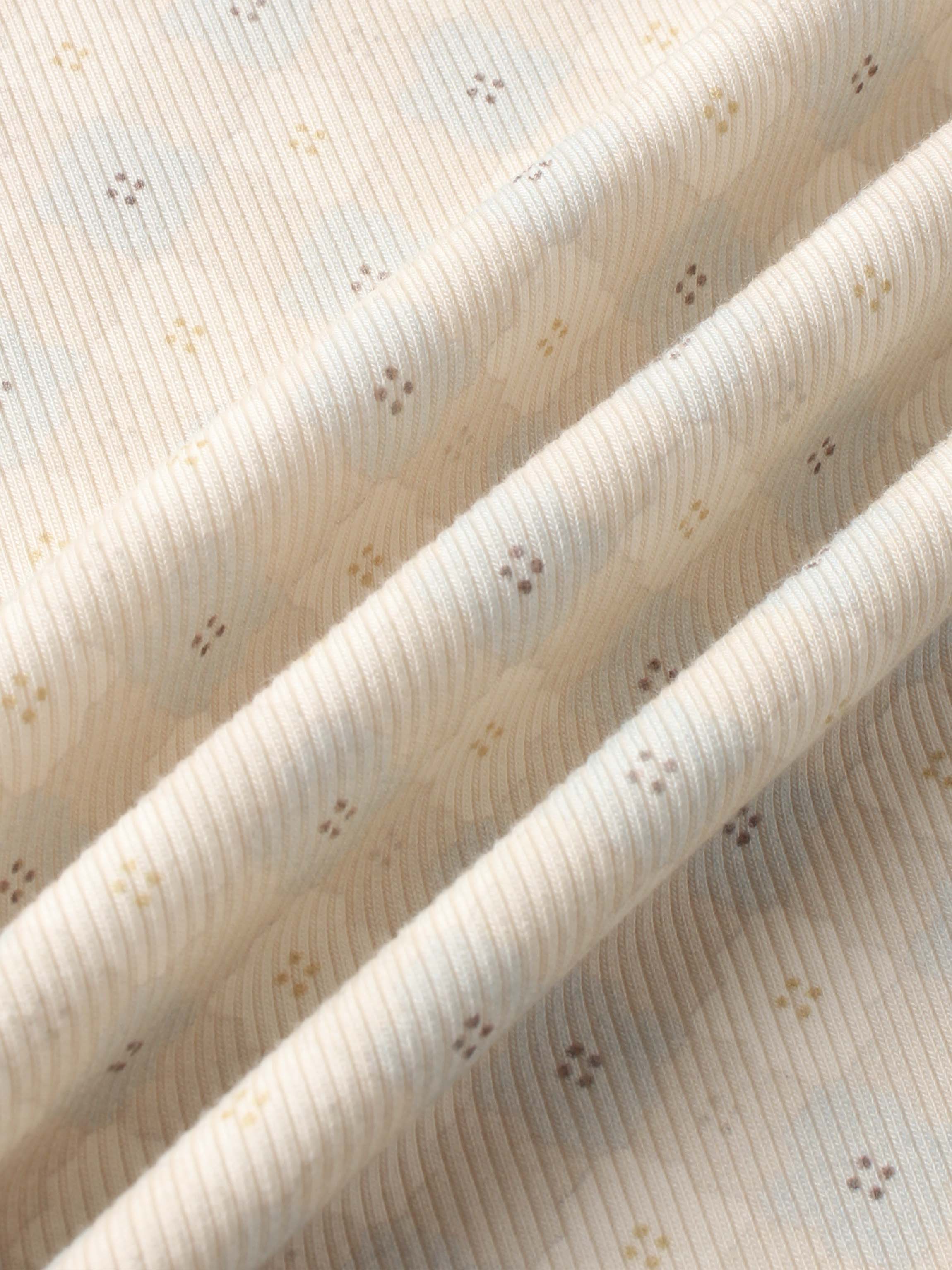 Little Button Blanket swaddle; cream ribbed fabric with tiny brown and yellow dot accents