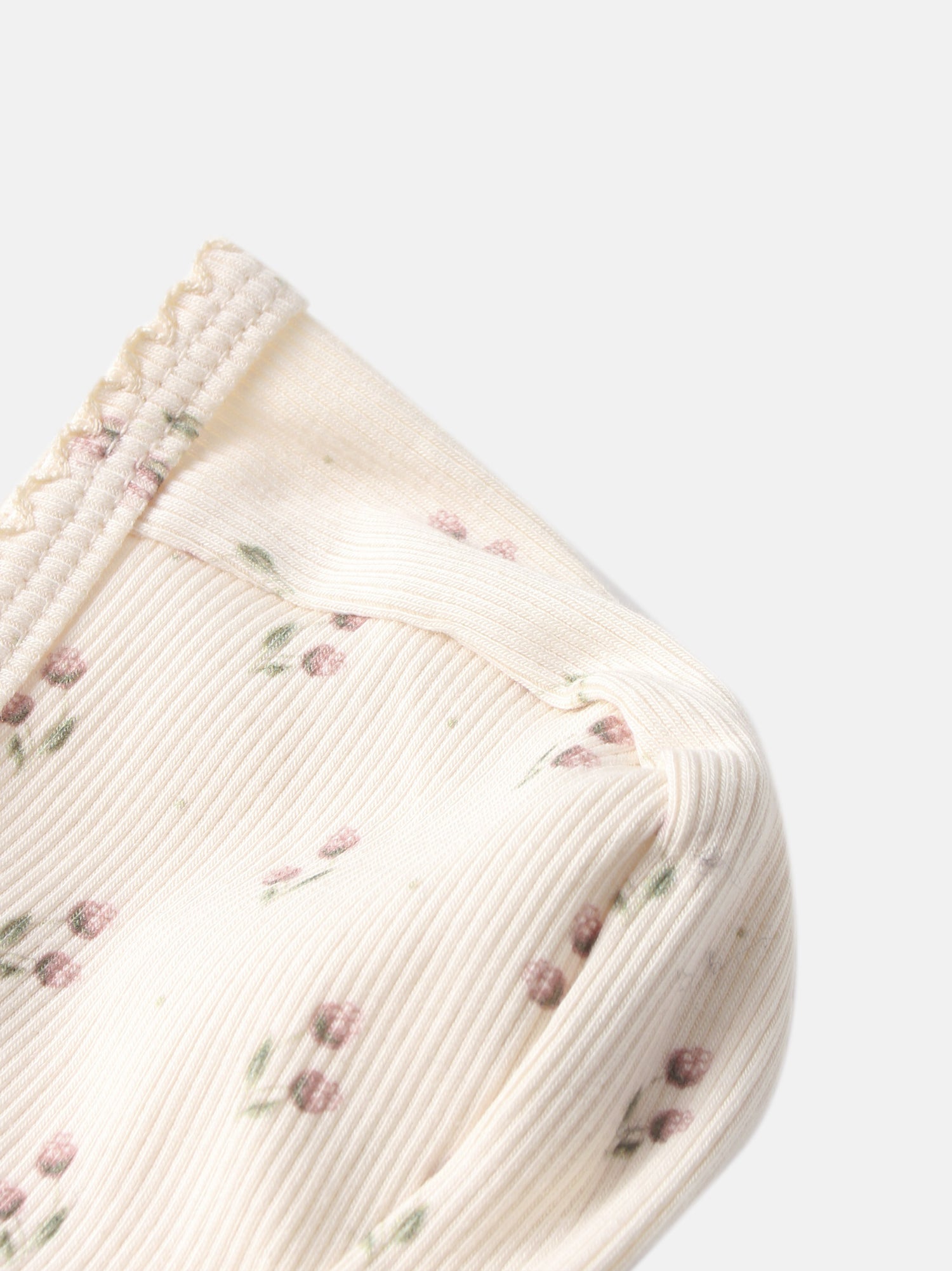 Tiny Tulip Bonnet by Adee; cream girls’ knit bonnet with pink floral print and ribbed edge.