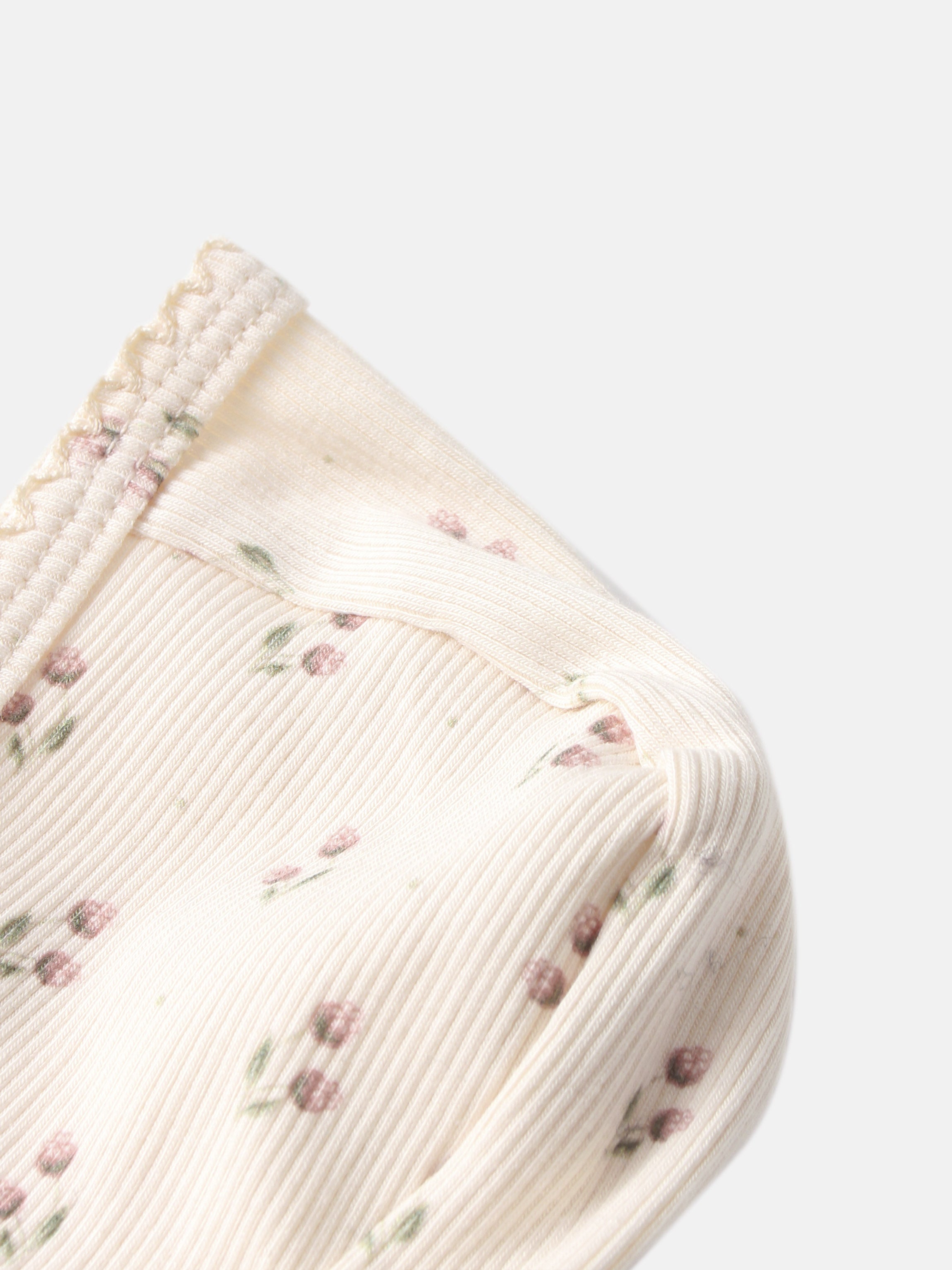 Tiny Tulip Bonnet by Adee; cream girls’ knit bonnet with pink floral print and ribbed edge.