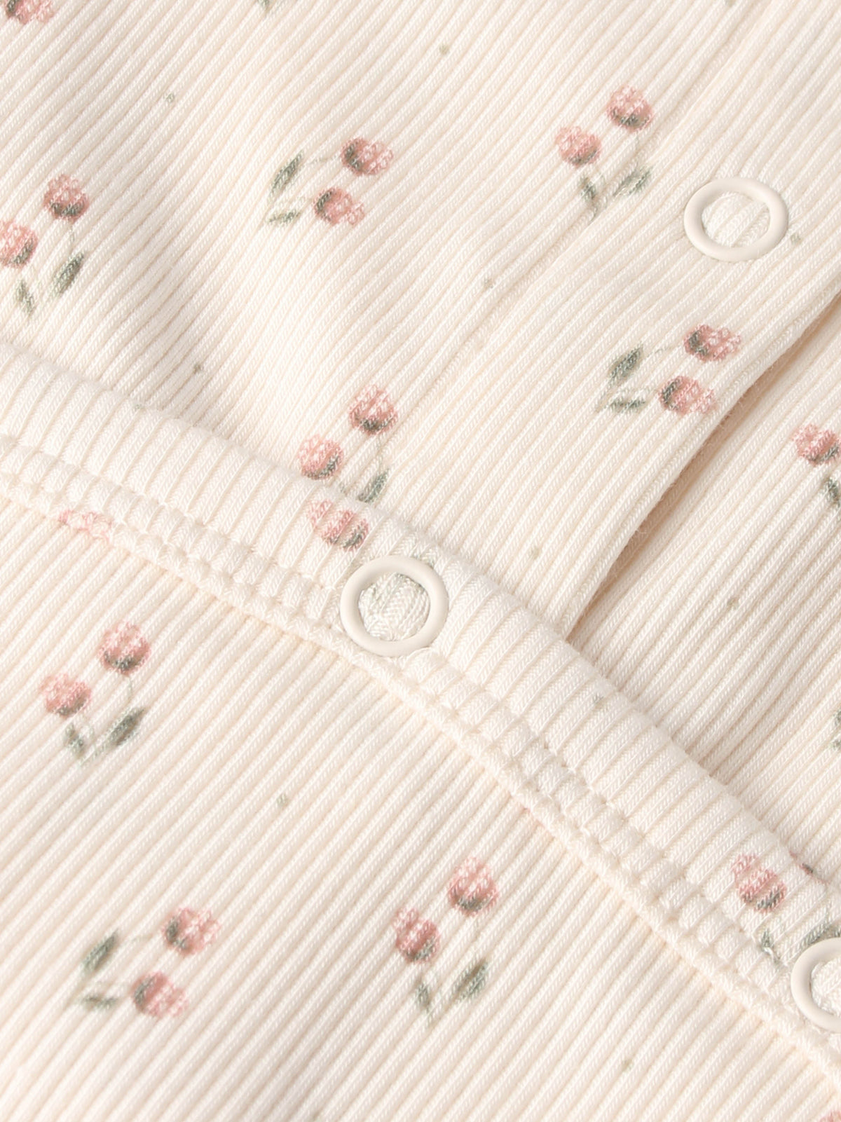 Tiny Tulip Stretchy girls knit fabric by Adee with pink floral print and white snap buttons.