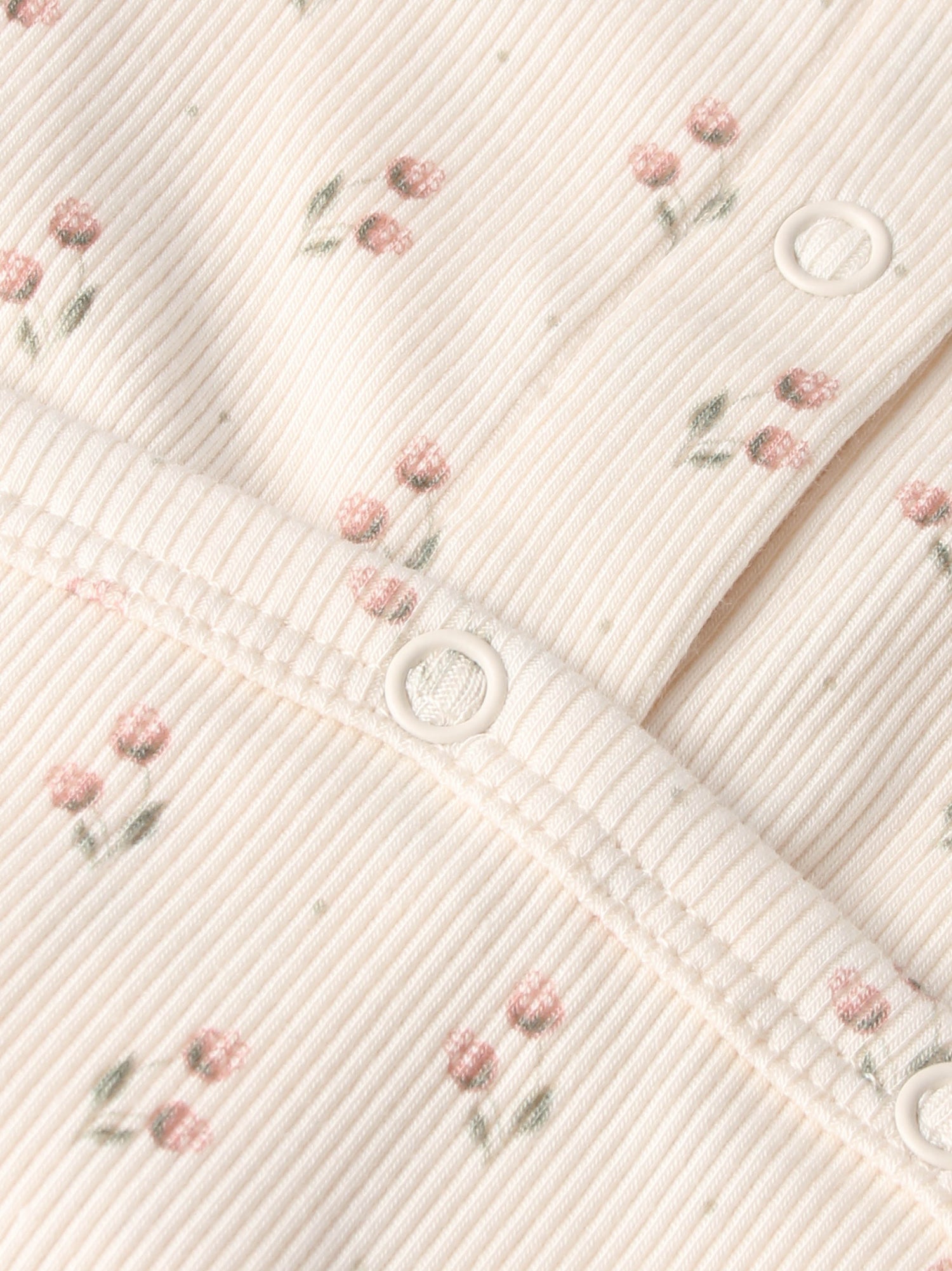 Tiny Tulip Stretchy girls knit fabric by Adee with pink floral print and white snap buttons.