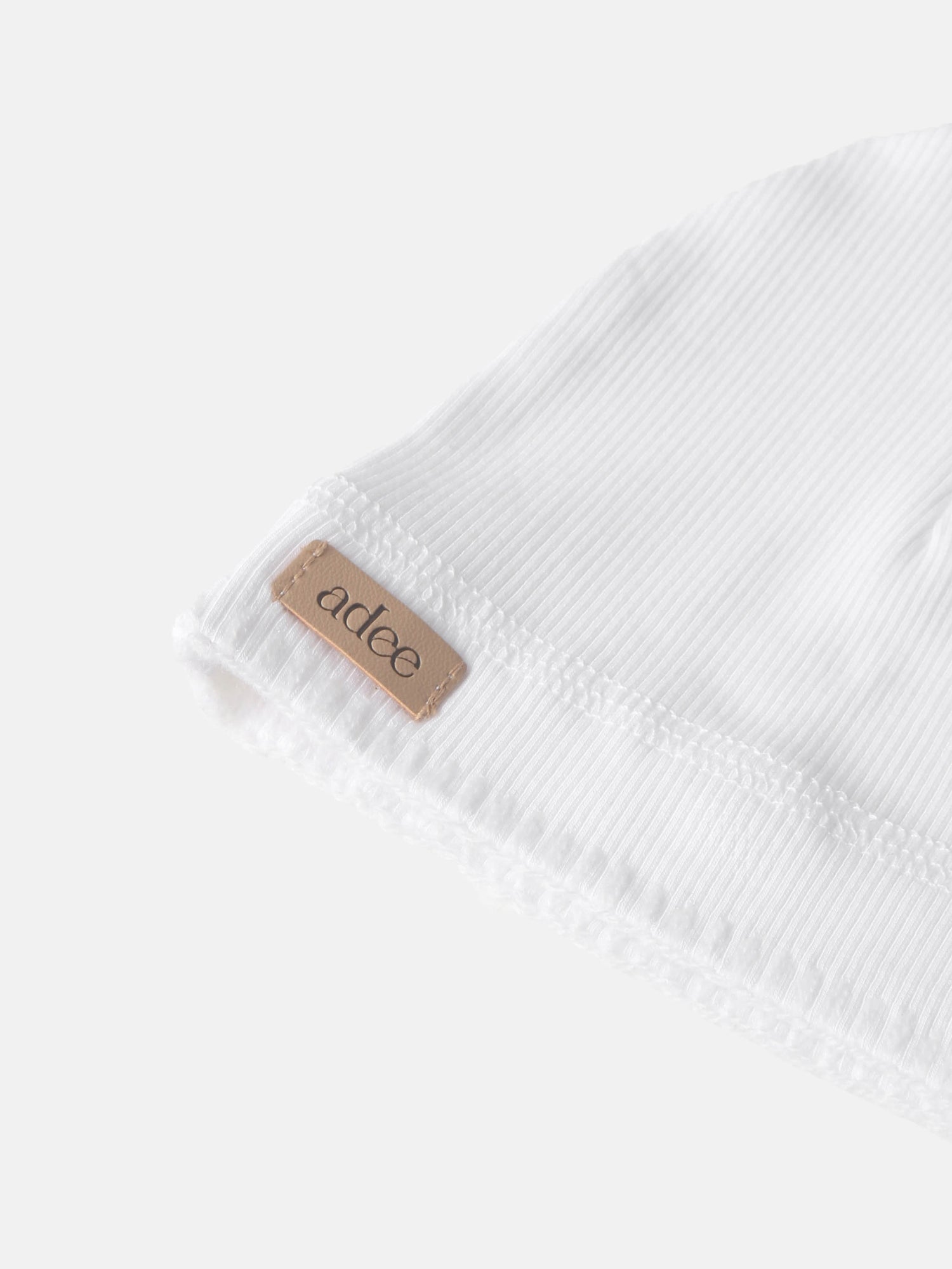 Legacy Stitch White layette set, unisex Adee brand in ribbed cotton with tan label.