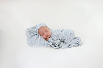 Heritage Herringbone Blue layette set, baby swaddled in blue herringbone fabric.