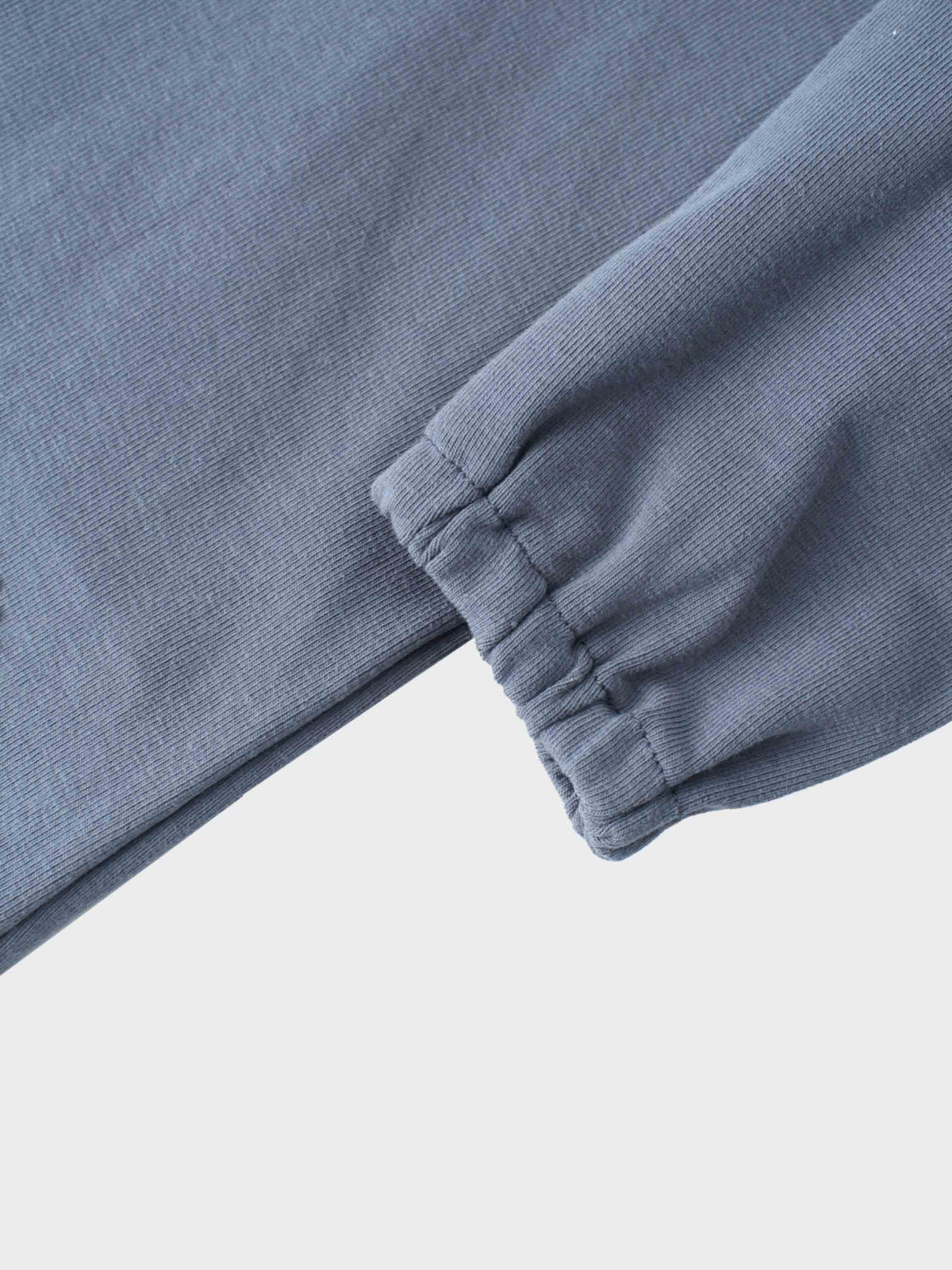 Close-up of a light blue cotton hoodie sleeve with elastic cuff from a baby girl hoodie set.