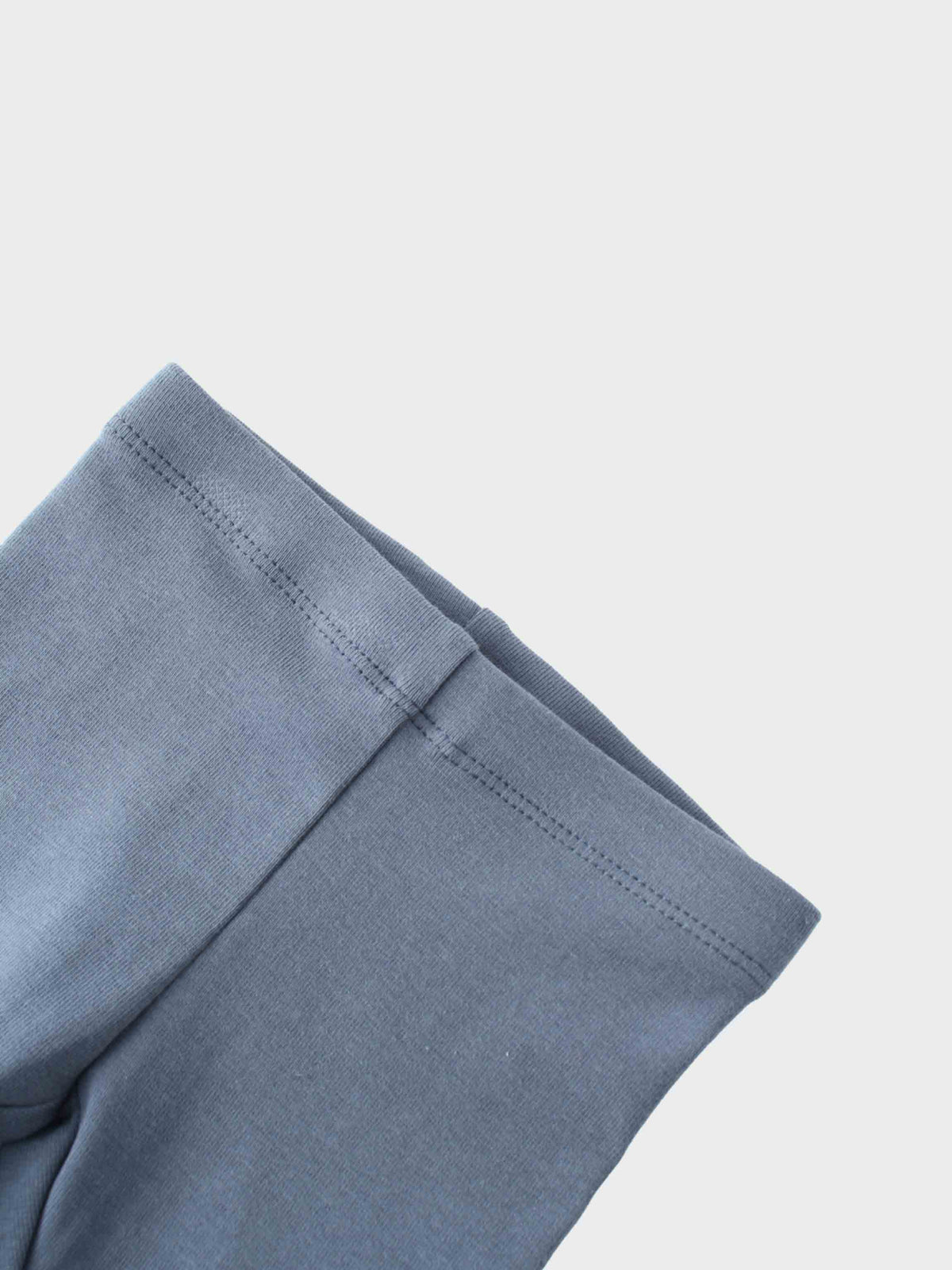 Close-up of light-blue cotton hoodie sleeve seam from a baby girls hoodie set.