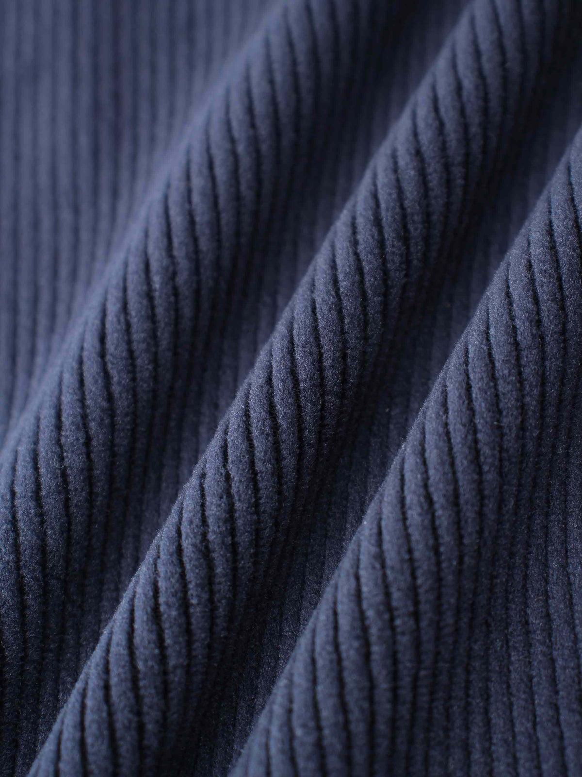 Navy ribbed velour fabric close-up from plush pajamas.