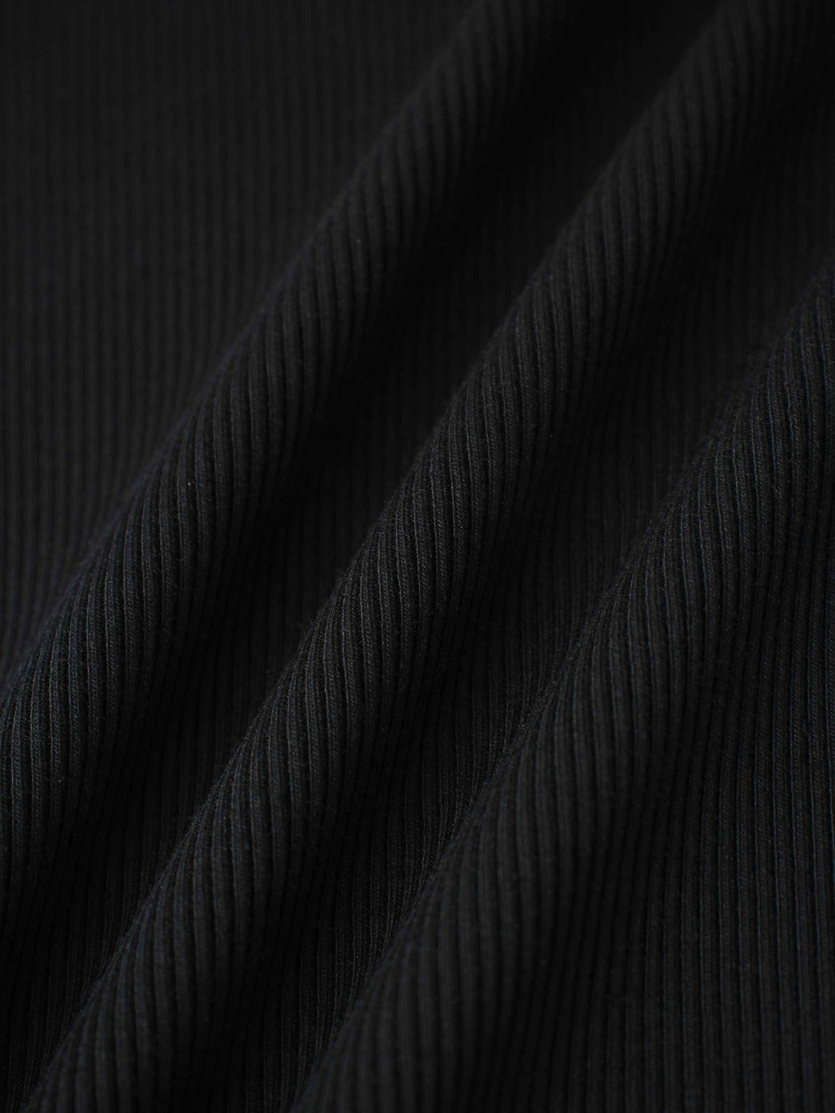 Close-up of black ribbed fabric for a soft, breathable mock-neck shirt.