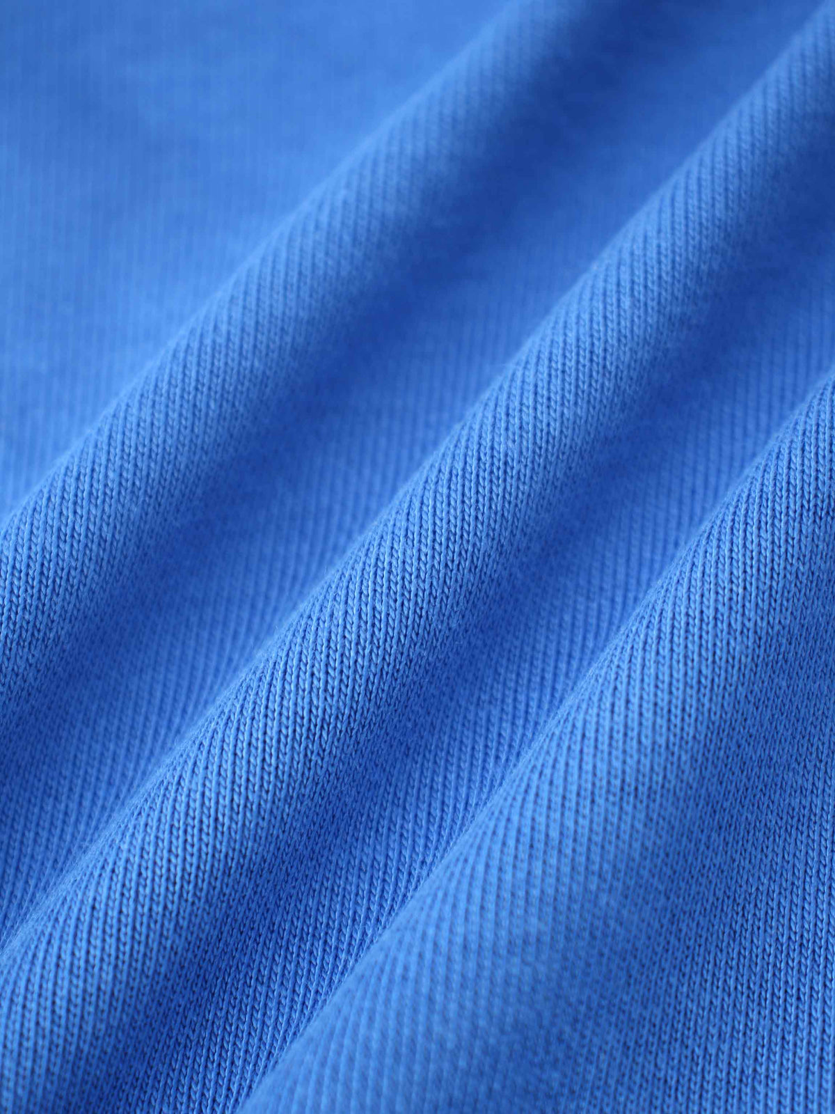 Close-up of royal blue sweatshirt knit fabric with soft texture and folds.