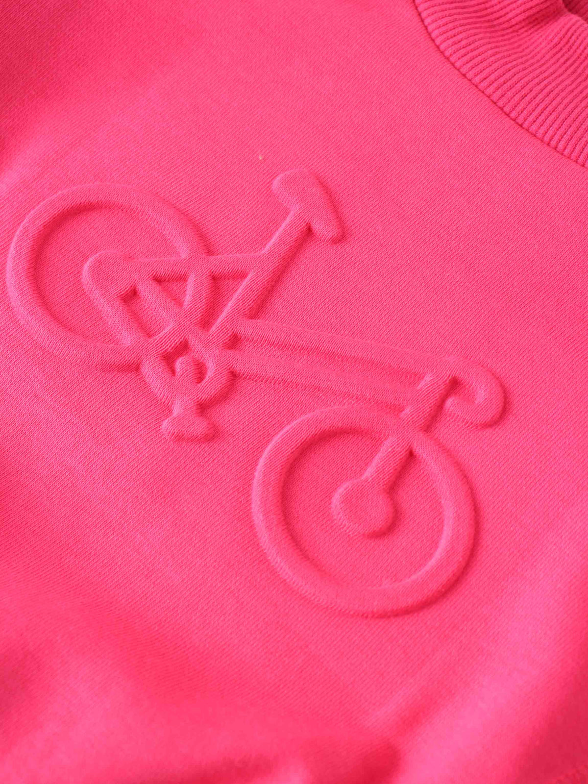 Neon pink bike sweatshirt with embossed bicycle emblem at center and sporty side stitching.