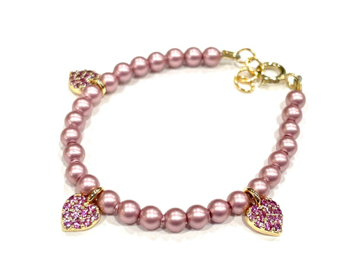 Pearl &amp; Ruby Bracelet with pink pearls and two gold heart charms encrusted with pink stones.
