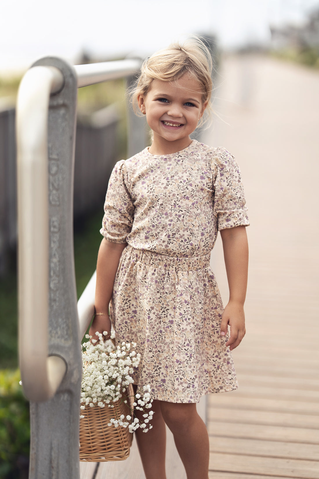 Purple Flower Skirt on a smiling girl in a beige floral dress, holding a basket of white flowers.