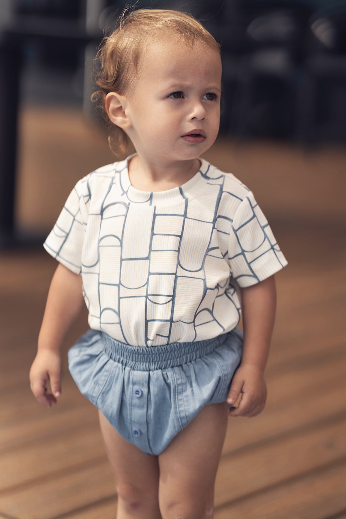 Paneled bloomers in blue denim with elastic waistband and front button placket; unisex kids&
