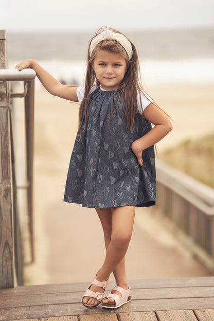 Denim Heart Jumper worn by a girl on a beach boardwalk, white tee sleeves, headband, pink sandals.