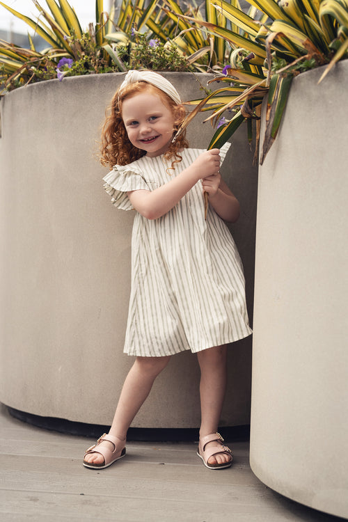 Green striped dress, dressy girls dress worn by a smiling young girl.