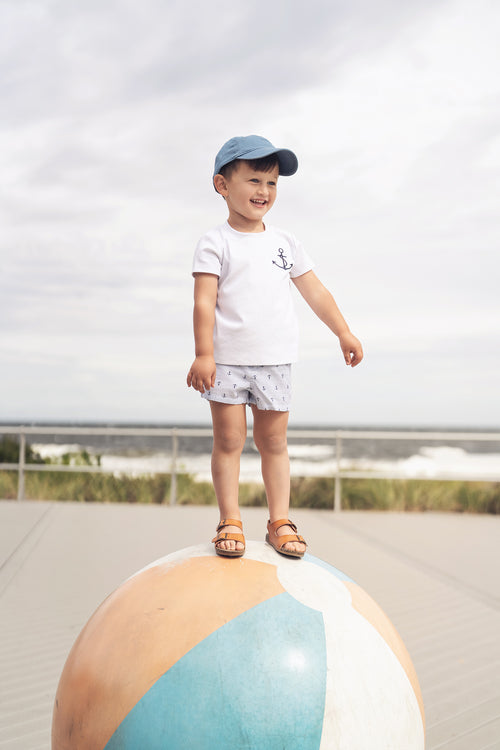 Child wearing white Embroidered Anchor Boxy Short Sleeve T-Shirt on a large beach ball