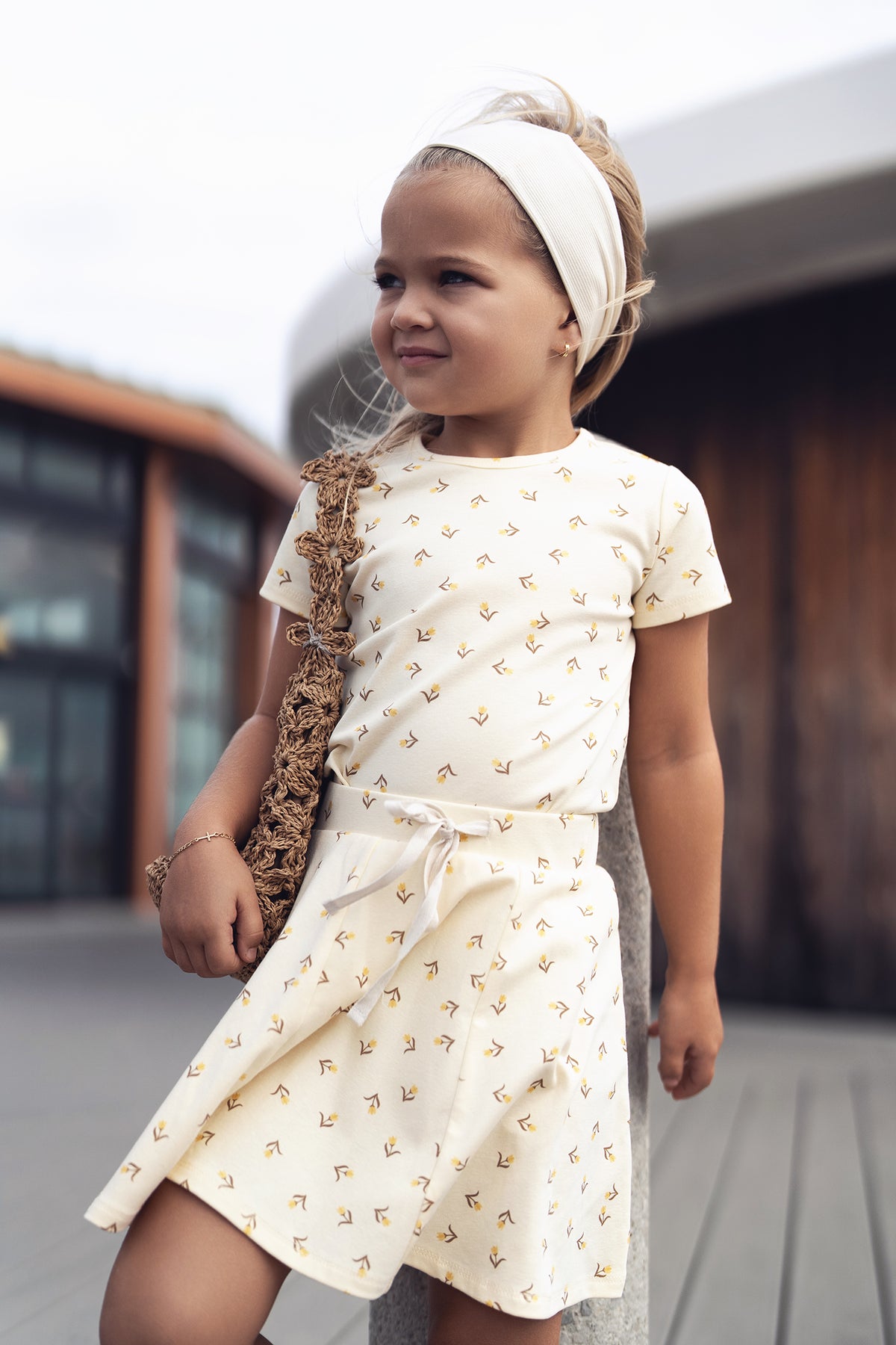 Butter Yellow Tulip Short Sleeve T-shirt with floral prints worn by a young girl with a cream headband.