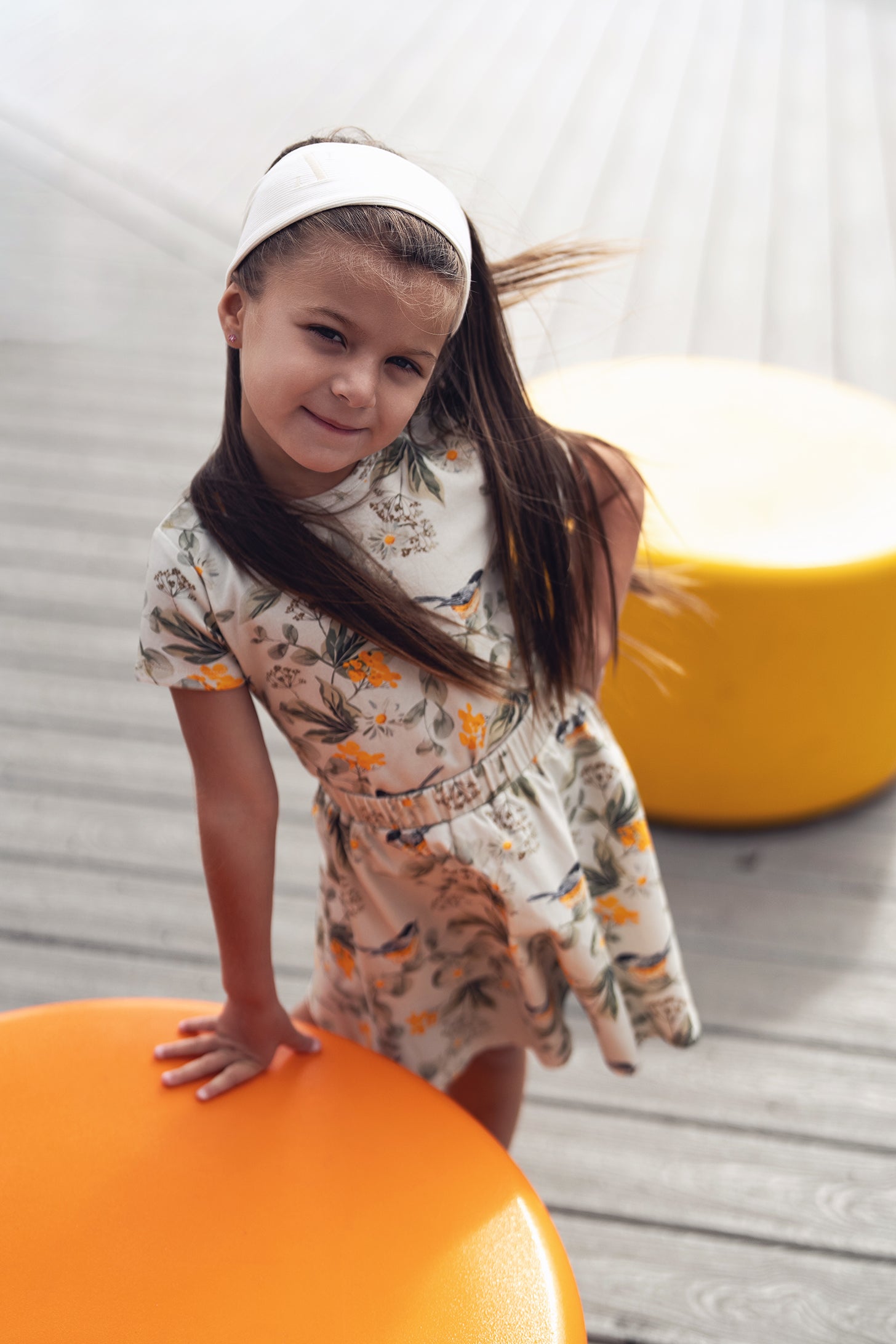 Garden Finch Circle Skirt on a girl in a floral dress with a white headband outdoors.