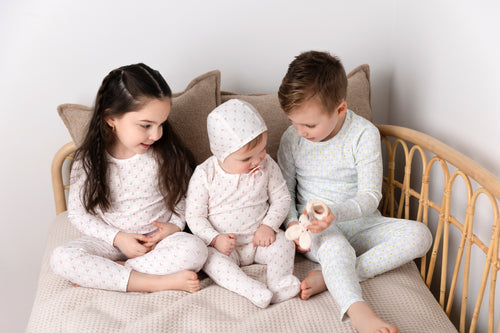 Cherry Window Pajamas for girls by Adee; light pink plaid grid, three children in matching pastel pajamas on a bed.