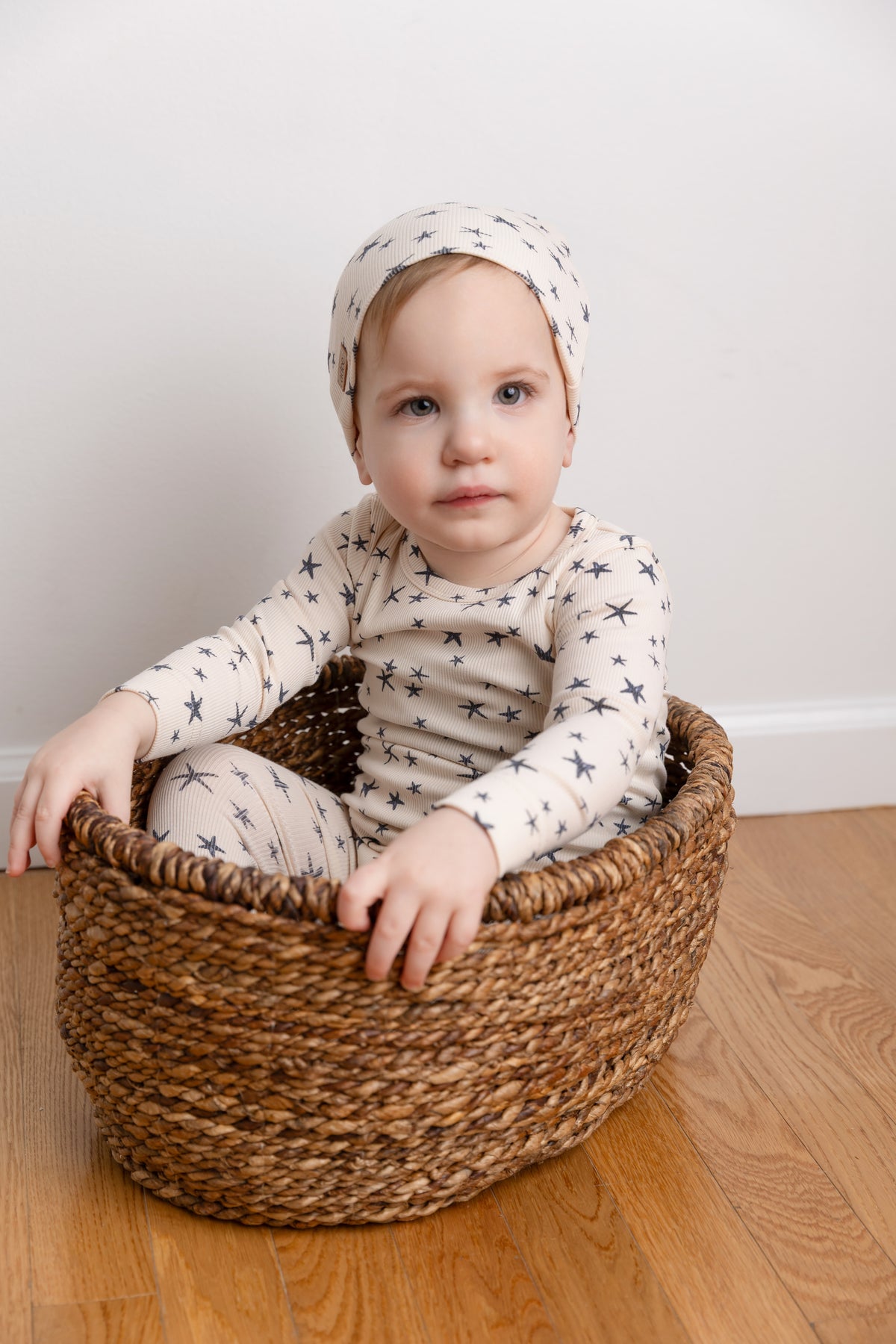 Star Stretchy boys stretchies beige star-print outfit in a woven basket