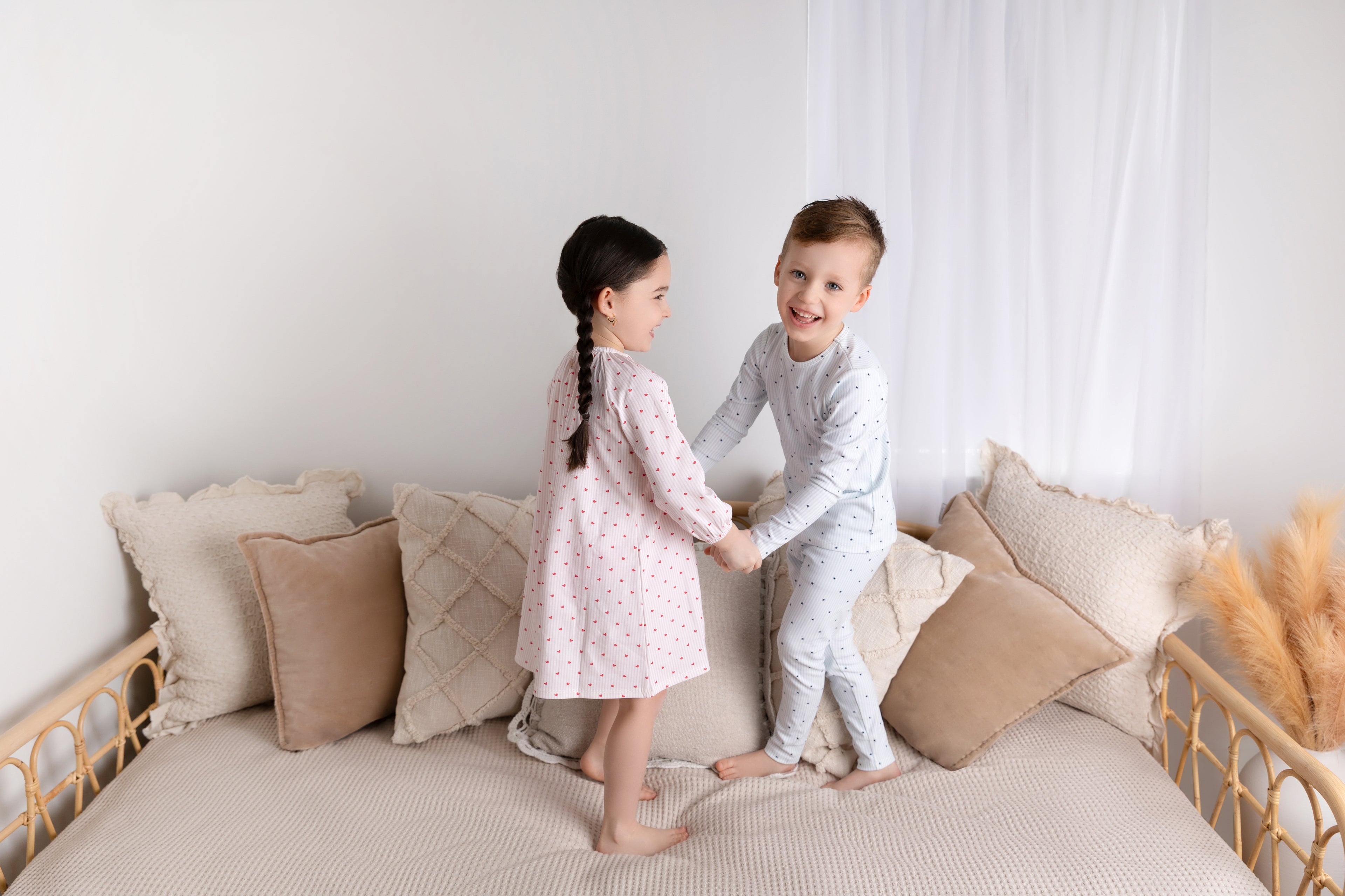 Pink Heart Nightgown for girls; two kids in sleepwear on a bed, pink heart-print nightgown and blue dotted pajamas.
